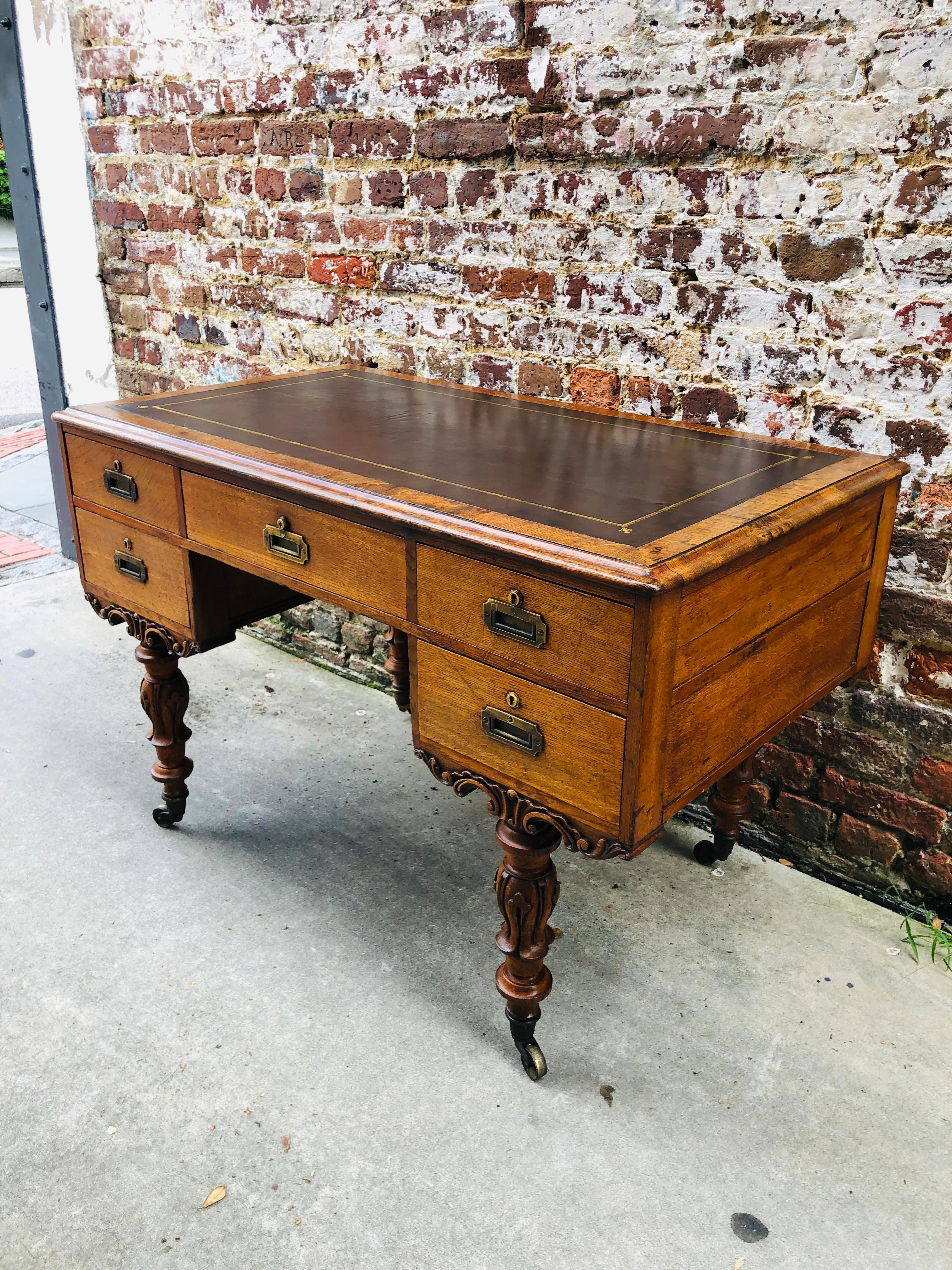 Irish Campaign desk with removable legs late 19th century with hand tooled leather top. Elaborately carved legs and base. FINISHED back.