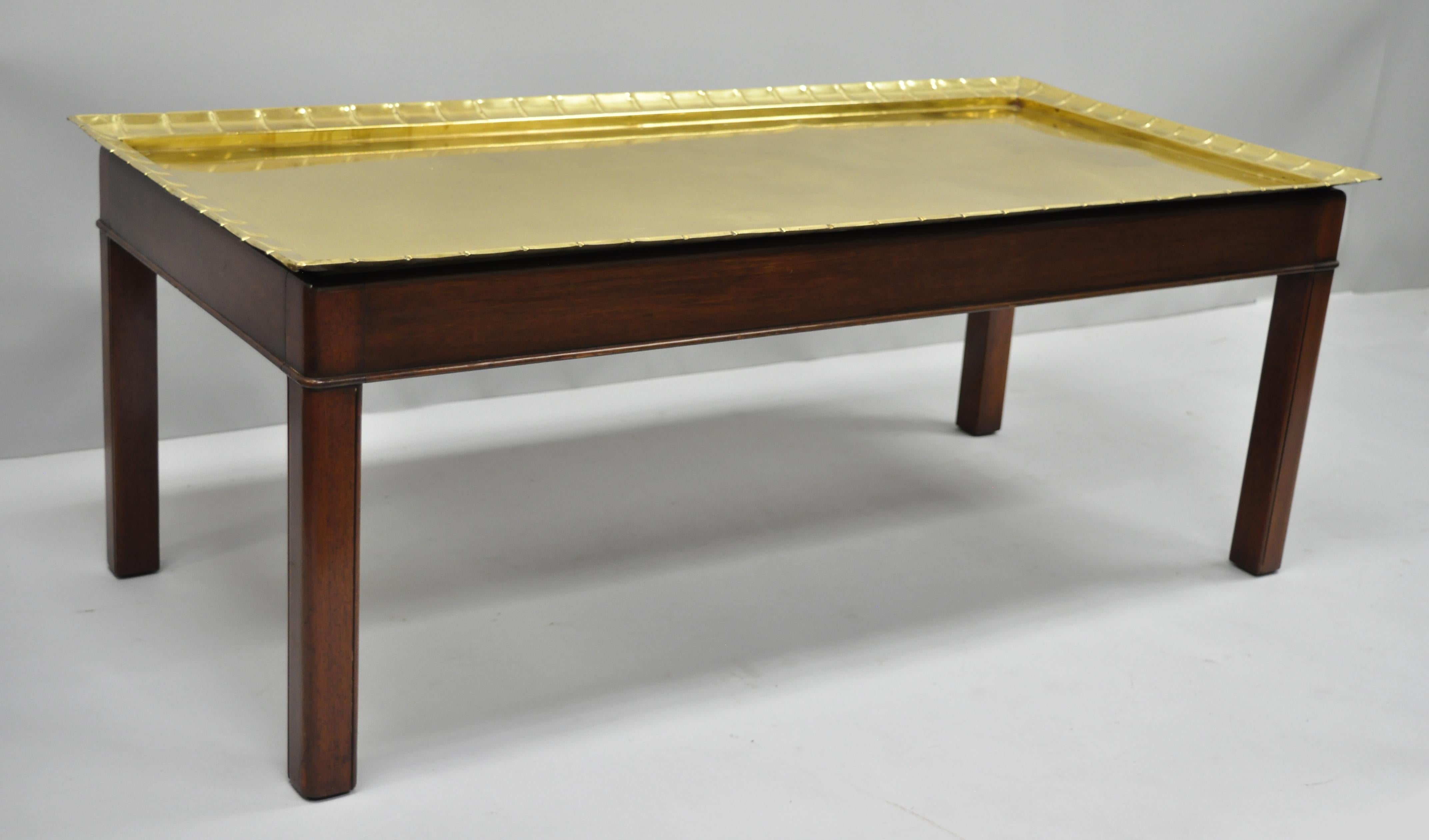 Early 20th century English Campaign style mahogany and scalloped edge brass tray top Georgian style rectangular coffee table. Item features a solid brass removable tray top with riveted iron supports to the underside, shapely scalloped edge, solid