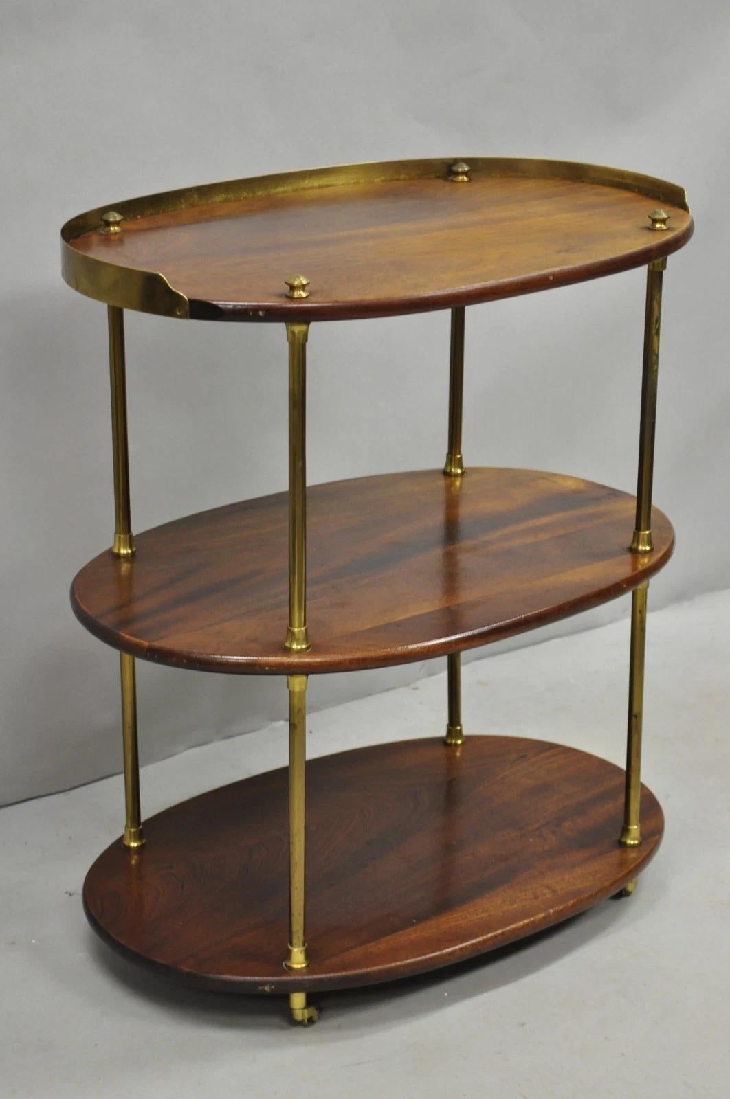 Please message us with your zip code to request a more reasonable domestic U.S. shipping quote.

Antique English Campaign Style Mahogany & Brass Oval 3 Tier Rolling Bar Cart Side Table on Brass Casters. Circa Early 20th Century. Measurements: 30