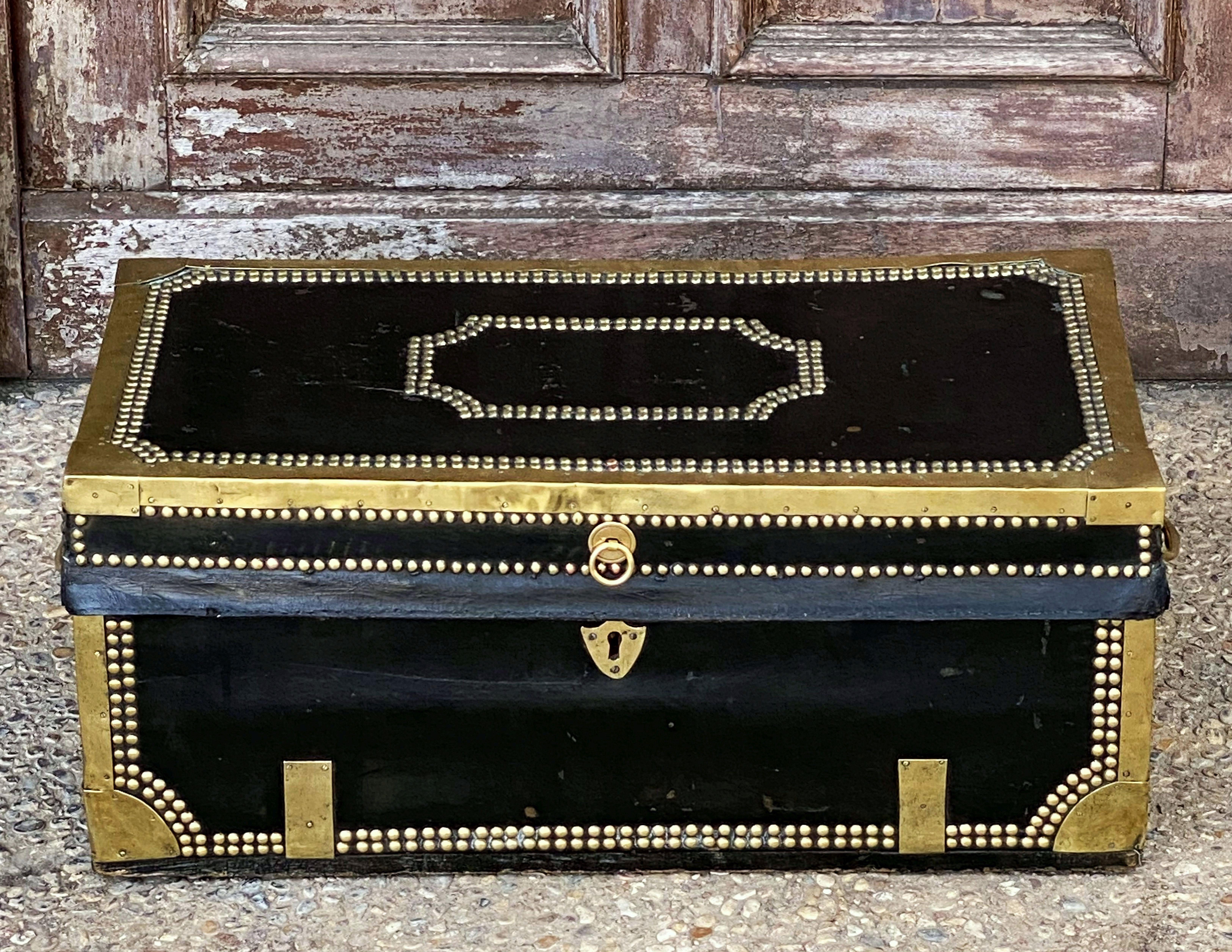 A handsome small-sized British officer's military Campaign camphor trunk or chest of brass-bound and studded leather over camphor wood, circa 1820. 
Manufactured by the British East India Company for an officer to carry his kit on Campaign.
With