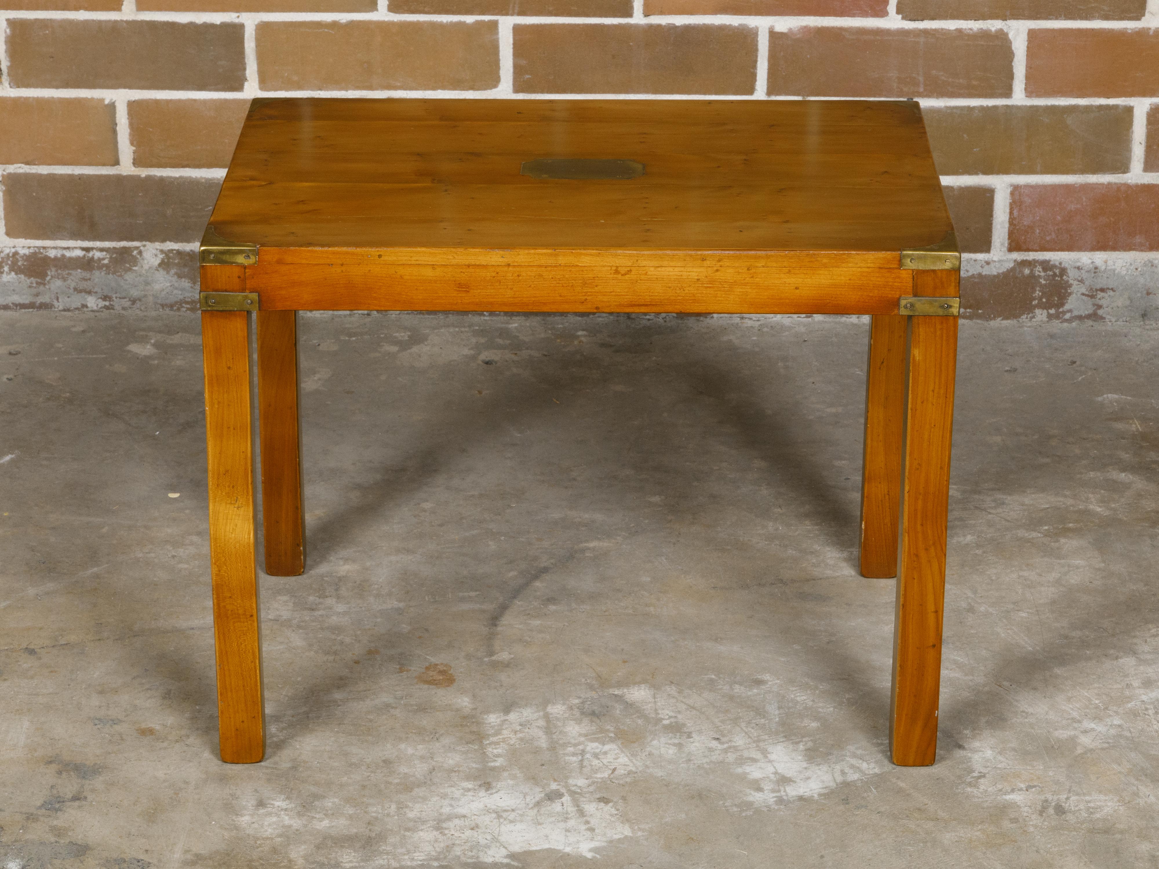 An English Campaign yew wood side table from circa 1920 with brass accents and straight legs. This English Campaign yew wood side table, dating back to circa 1920, encapsulates the refined elegance and practical design characteristic of the period.