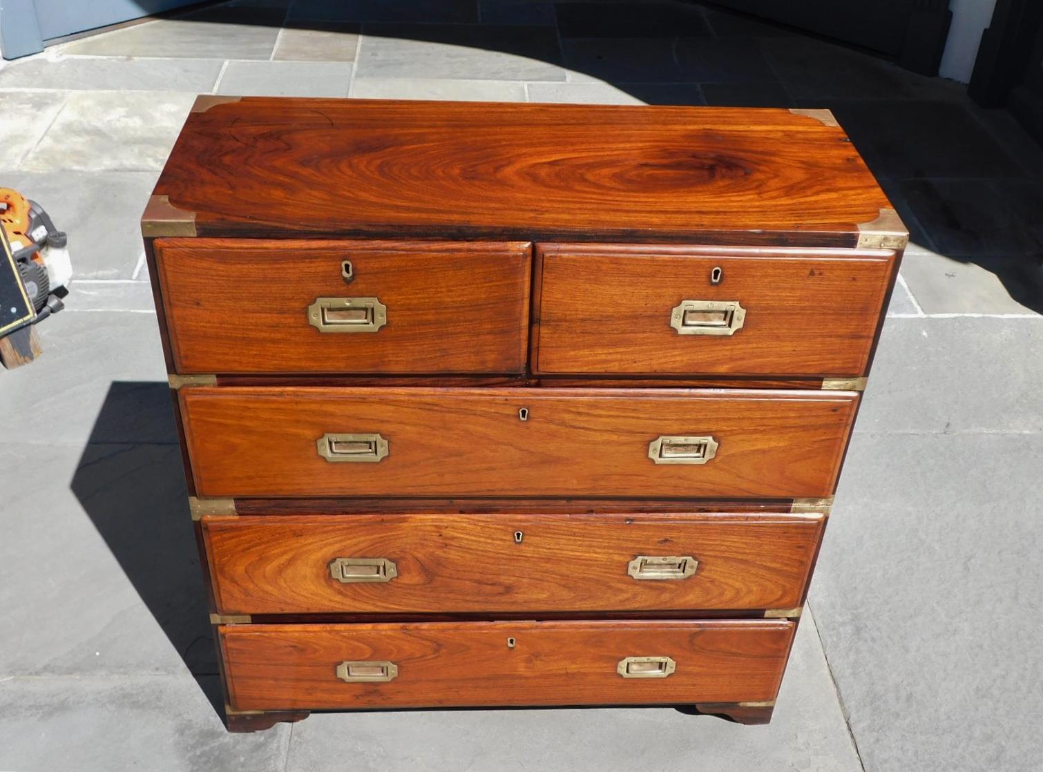 English camphor wood five-drawer military campaign chest with the original recessed brasses, key hole escutcheons, brass corner mounts, and terminating on the original bracket feet, Early 19th century. Campaign chest separated in two pieces to carry