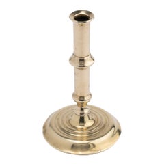 English canon barrel brass candlestick on domed base, 1720-40