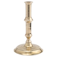 English canon barrel brass candlestick on domed base, 1720-40