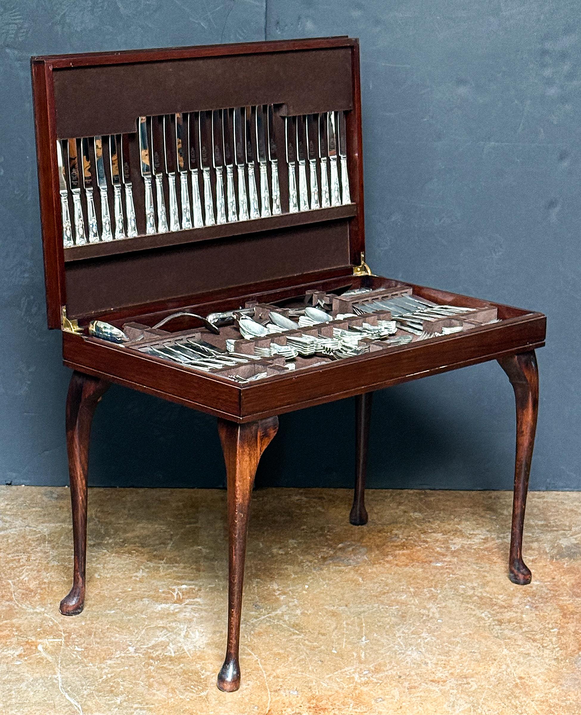 A fine English canteen of mahogany on cabriole legs, containing a fitted compartment with a twelve-place setting of King's pattern silver-plated cutlery.

The full set contains: 1 soup ladle, 1 gravy lade, 1 meat carving knife, 1 meat carving fork,