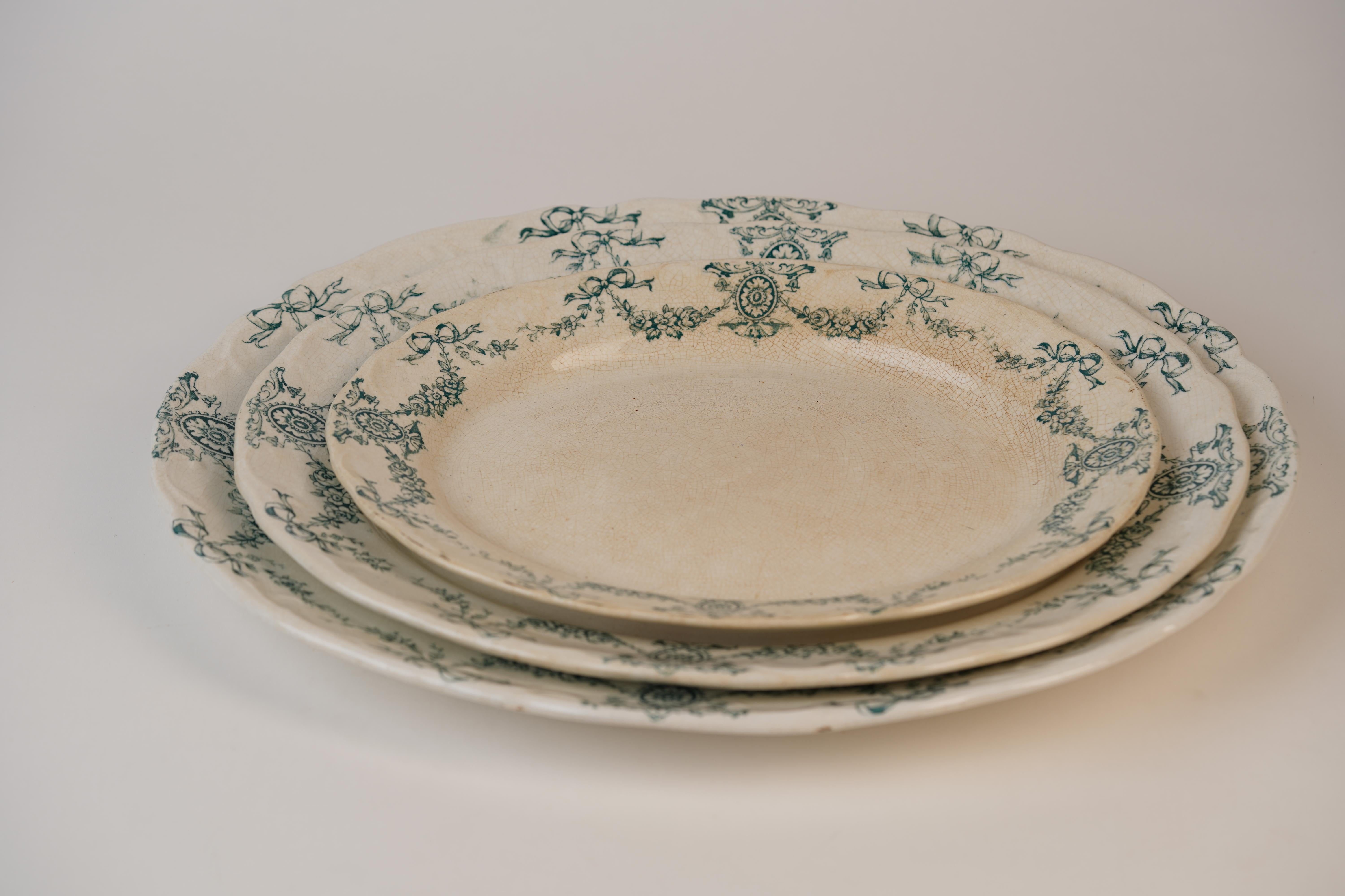 These antique oval platters are a fine example of English transferware from the early 20th century, part of the “Carlton” pattern produced by Barker Bros at the Meir Works in Longton, Staffordshire. What sets it apart is the delicate green