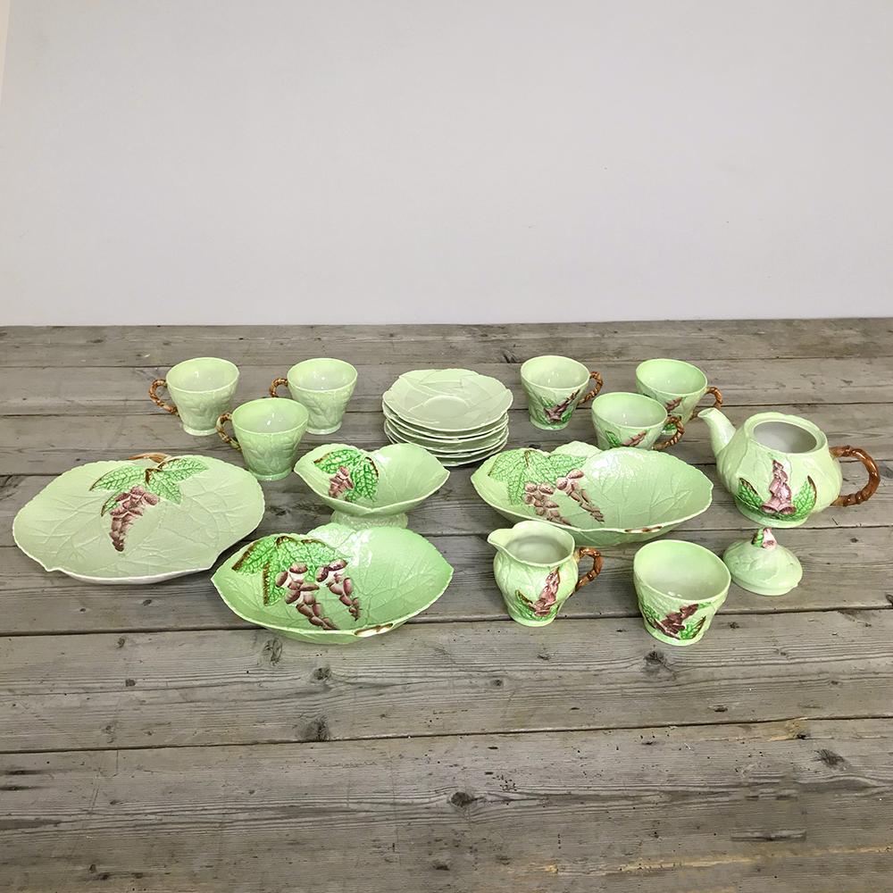 English Carlton Ware 19 piece tea serving set includes everything pictured. Each piece is meticulously hand-painted to depict ripe pomegranates on the vine in muted earth tones of green and a rich earthy red. In business for a century, Wiltshaw &