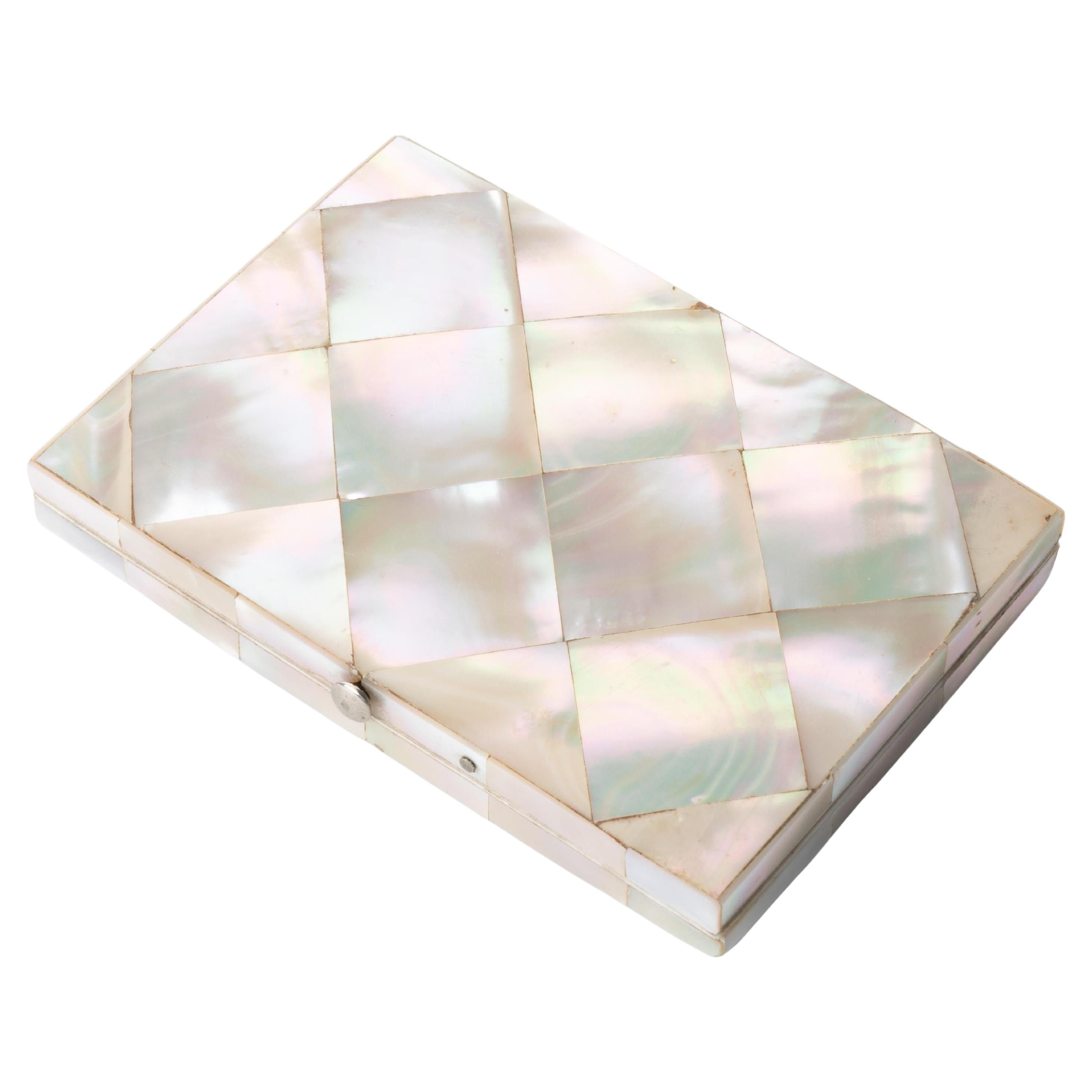 Carte du Visite (business card) case of Mother of Pearl laid in diagonal squares with a floral engraving centering on an abalone square and banded in abalone with ivory inner lip. The interior consists of a gilt edge cobalt blue accordion file on