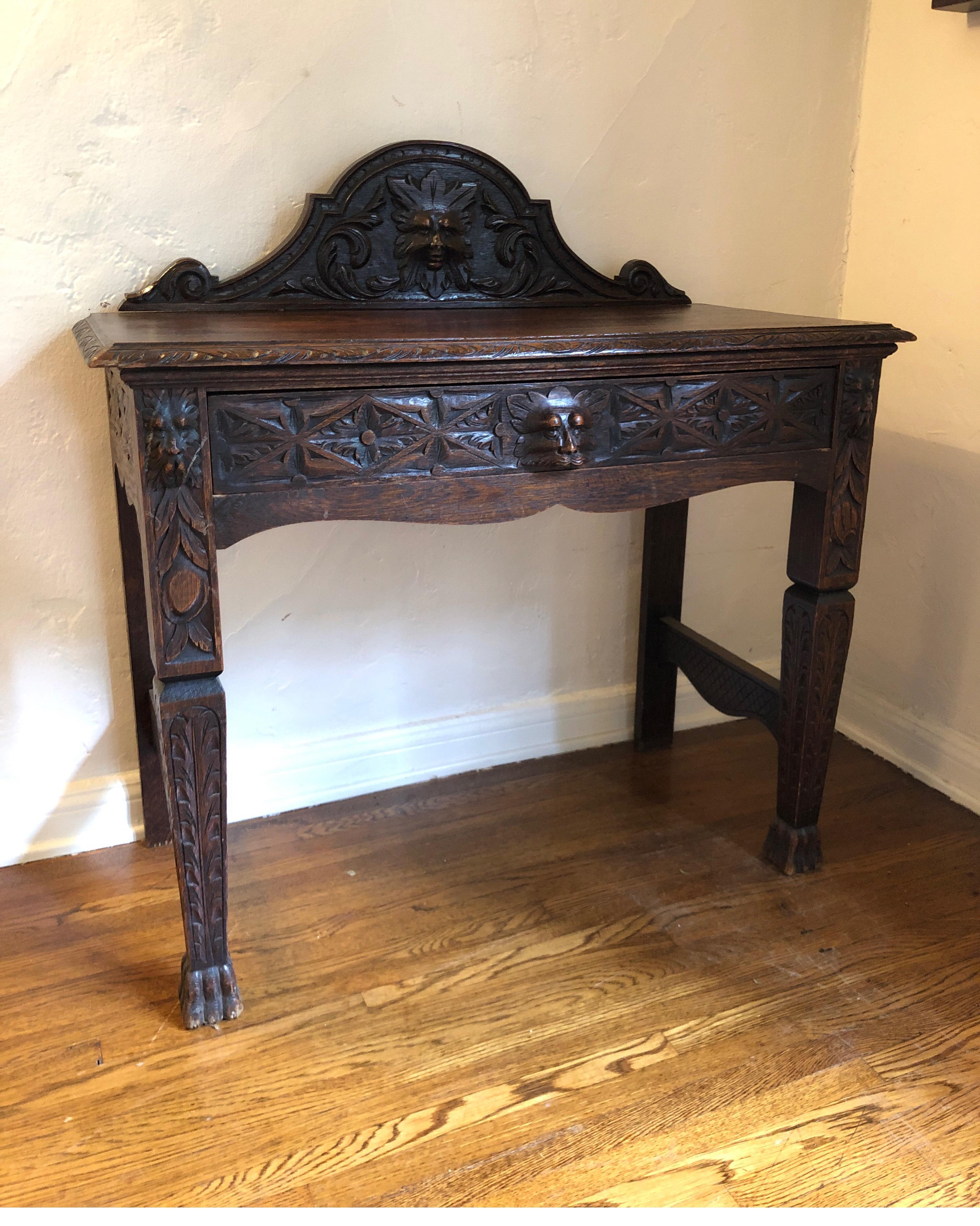 Green Man Edwardian Oak, a pagan deity of vegetation or rebirth. 
Carved antique oak hall table or entry table. Deep rich color with patina 

Has one drawer. Upper carved piece along the back is separate and secured to the top by dowels.

29.5