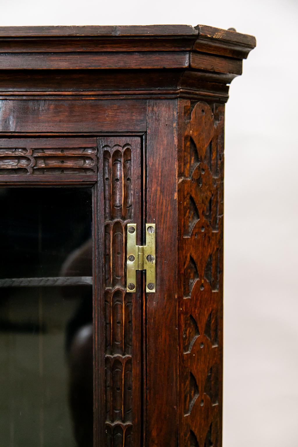 La puerta de este armario esquinero colgante de roble está tallada con estrías repetidas. Los retornos laterales están tallados con gotas de lágrimas estilizadas. El interior tiene dos estantes fijos en forma de mariposa.