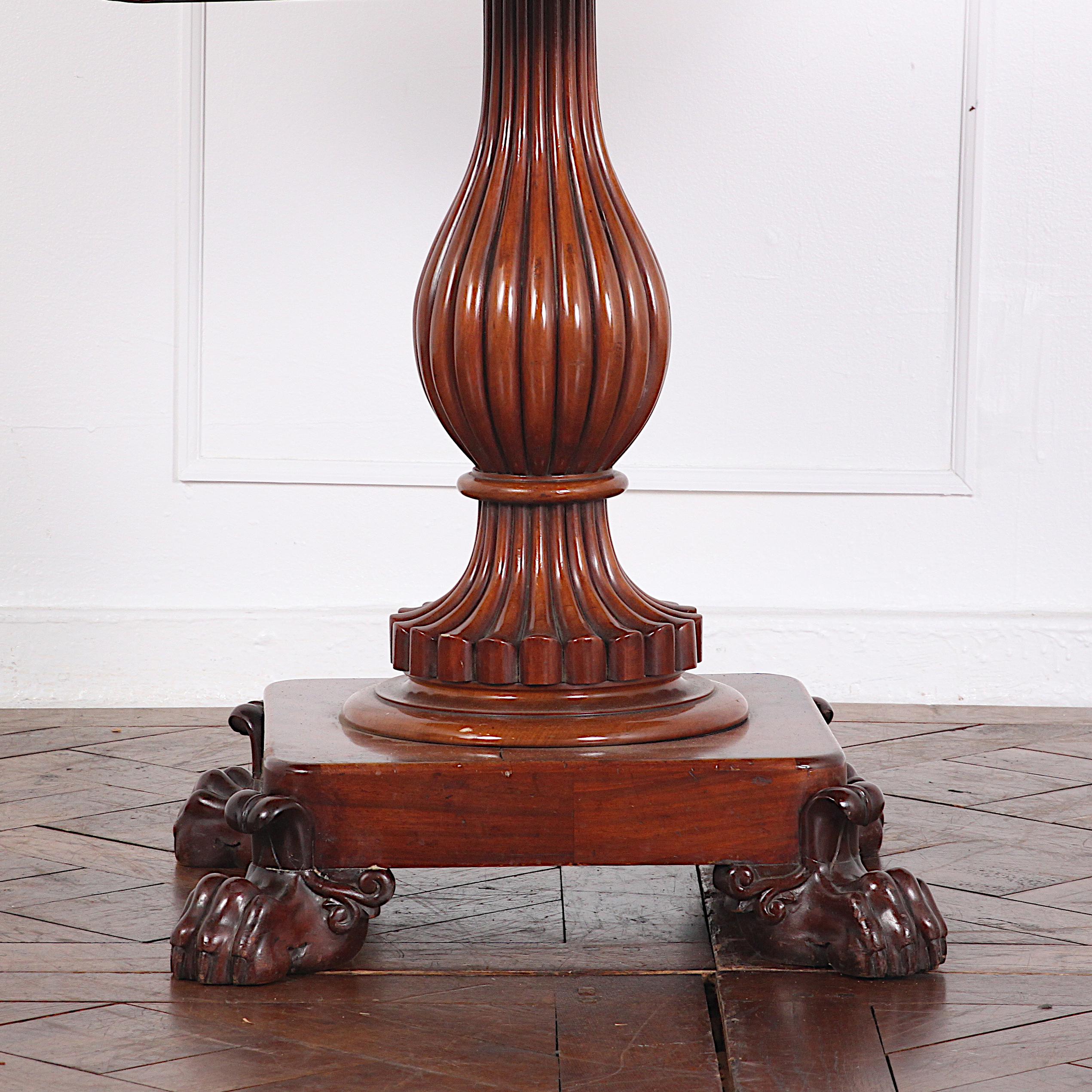Highly carved English mahogany flip top games table on pedestal.
