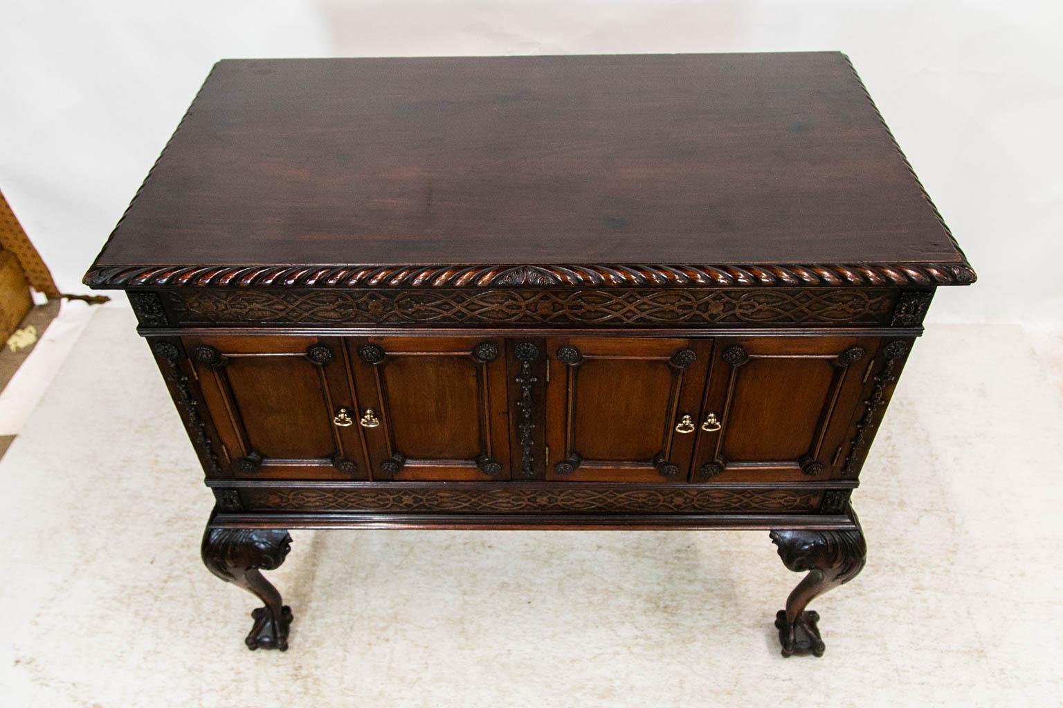 The top of this serving cabinet has a carved gadrooned molding. The frieze has blind fretwork. The right hand double doors are both functioning doors whereas the left hand is actually one single door. The blind fretwork in the upper frieze is
