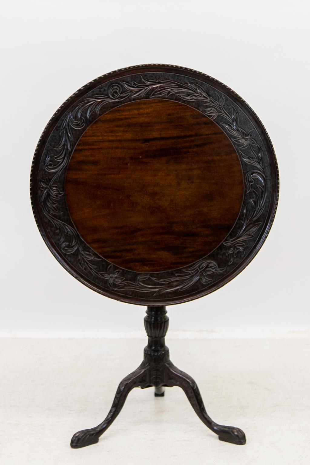 The dish top of this table has a carved repeating notch pattern. The inside border is carved with floral and leaf arabesques on a stipled background. The stem is reeded and has a carved fluted knop. The legs are carved from the knee to the toe.
   
