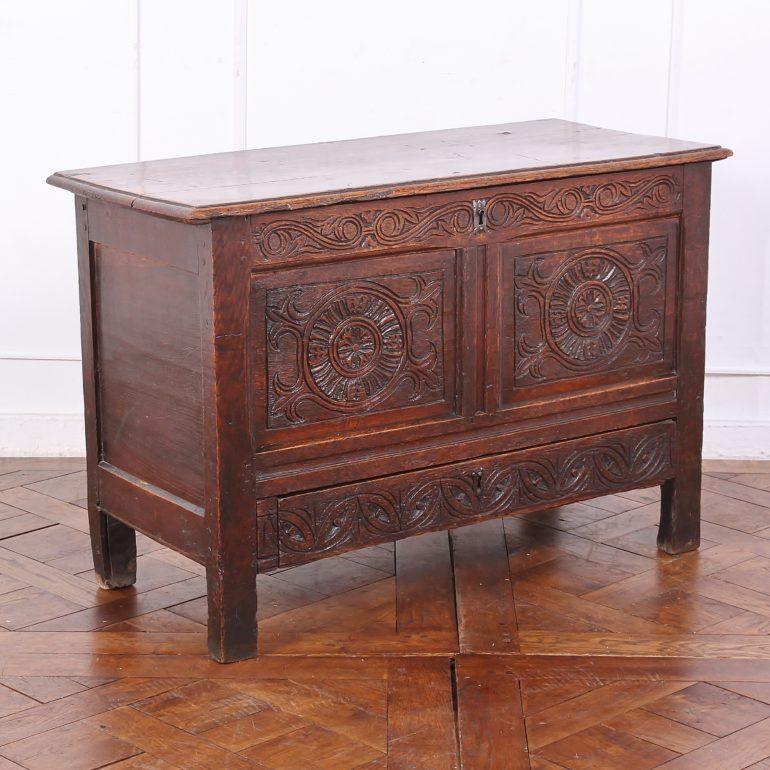 An English carved oak coffer or blanket box, with a hinged top and drawer below. 



 