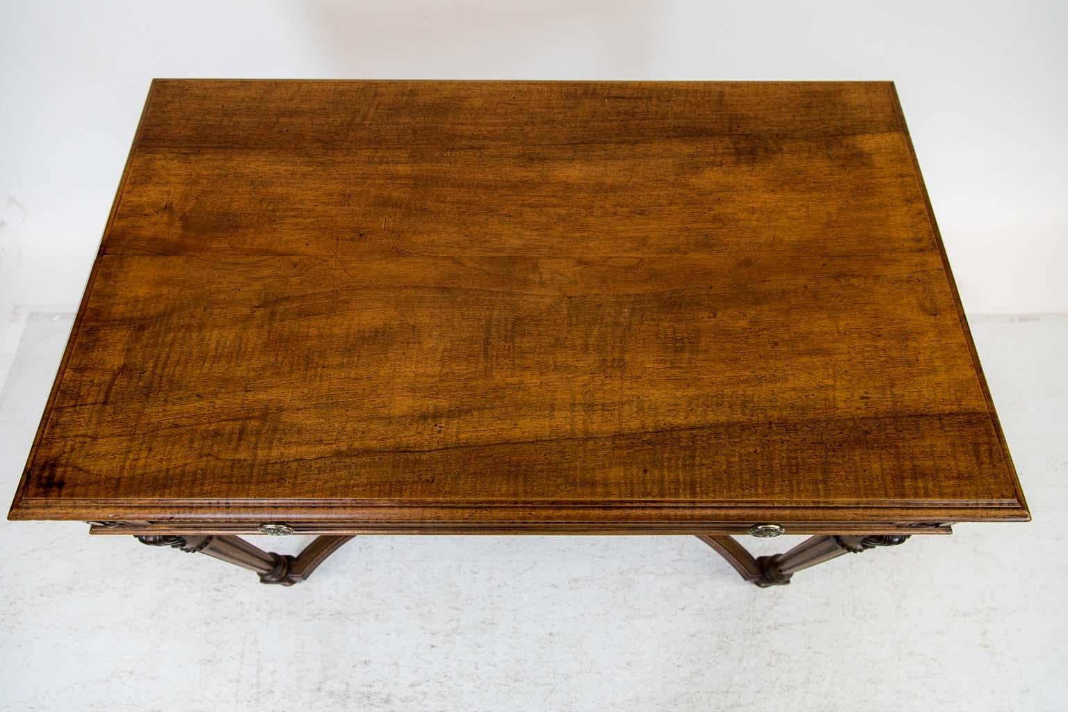 The top of this solid walnut carved center table has a carved molded edge on all four sides. The drawer and all three other sides have a recessed panel framed with carved tulip molding. The cast brass knobs(later) have a floral motif and all four