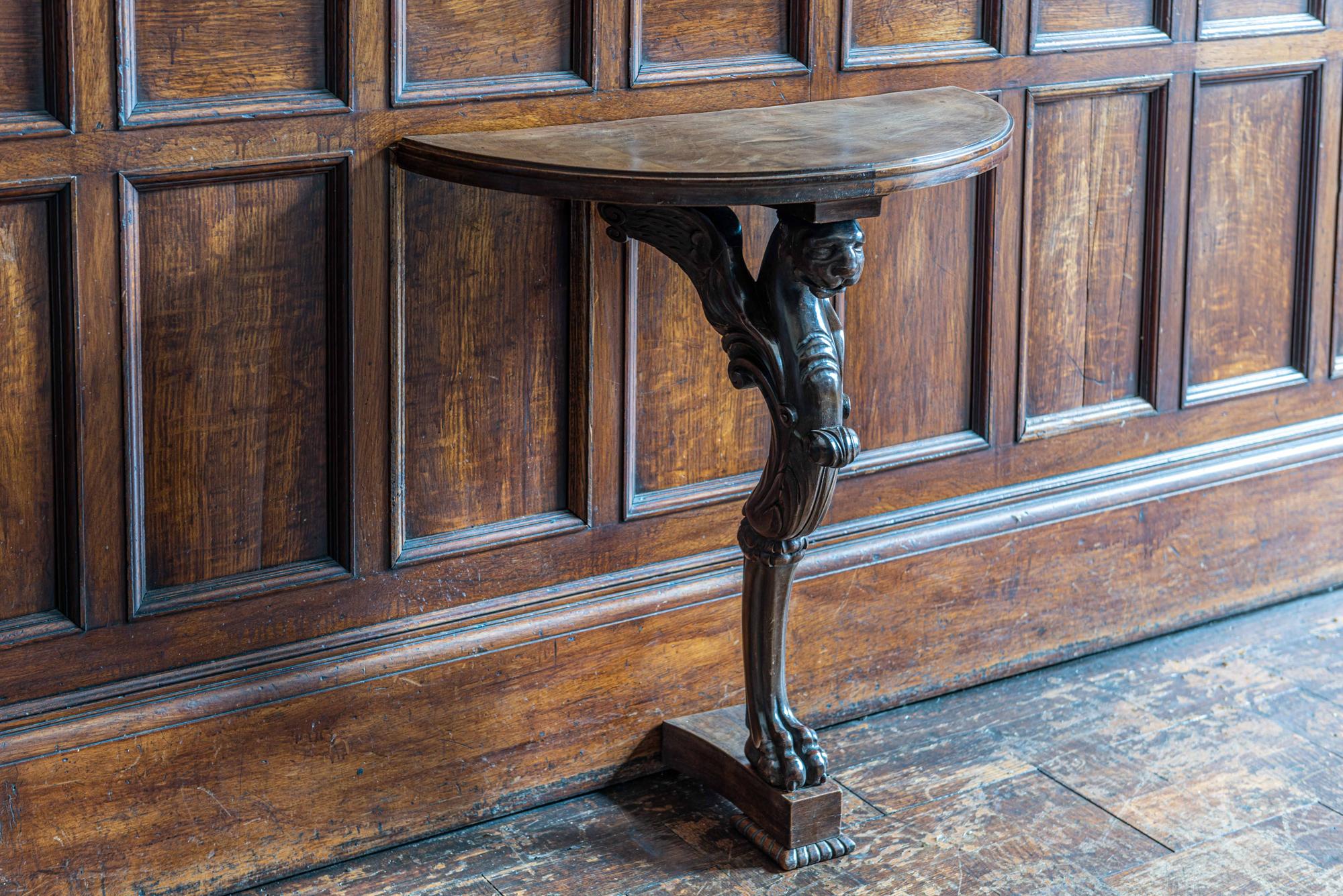 English carved winged lion demilune console table,
circa 1900.

A petite carved winged lion demilune wall-mounted console table.

Measures: 69 W x 31.5 D x 72 H cm.