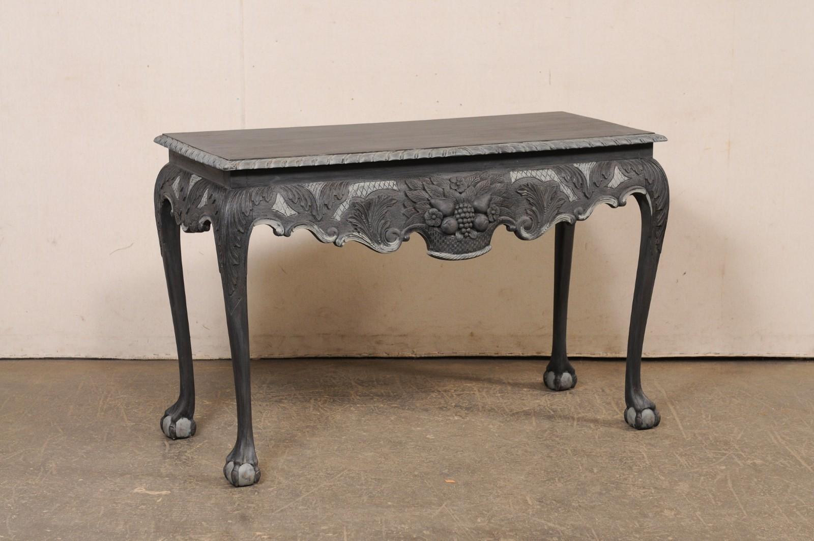 Console anglaise en bois sculpté et peint avec des pieds en forme de griffes et de boules. Cette table vintage originaire d'Angleterre présente un plateau rectangulaire dont le pourtour est sculpté d'une corde, surmonté d'un tablier qui présente une