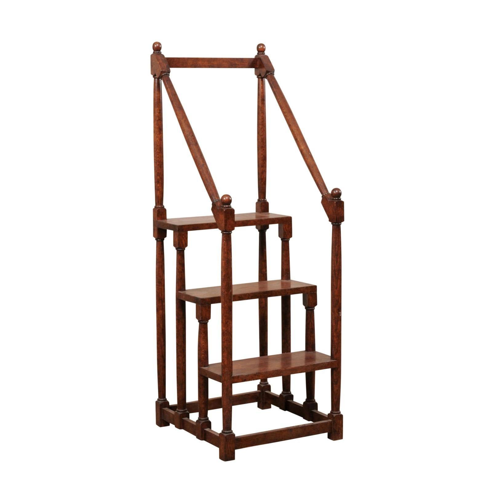 A vintage English carved-wood set of library steps. This oak wood step ladder from England is nicely-sized at just over 70 inches tall, and has three steps. The third, and top step, is approximately 38 inches from the ground- allowing you to get