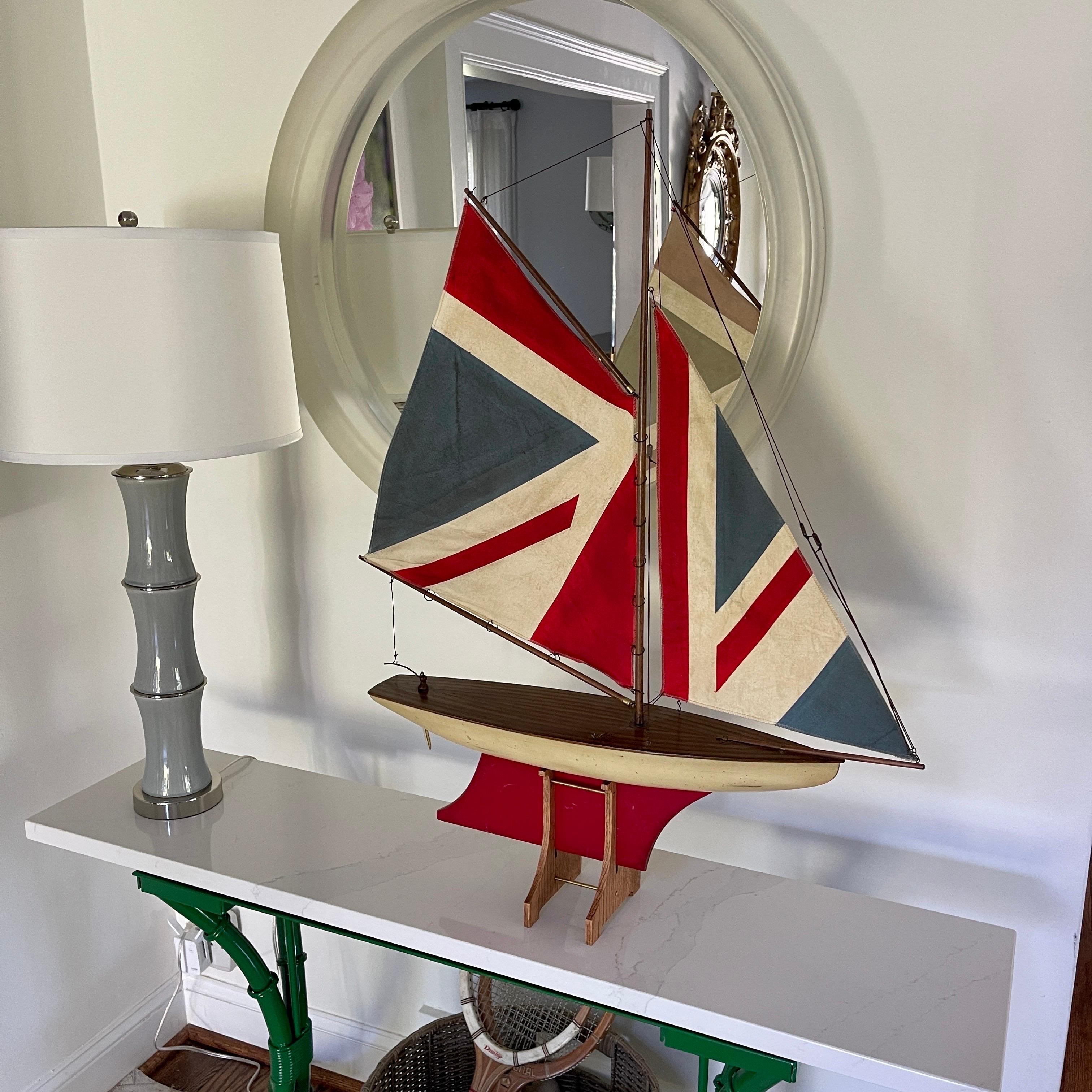 Vintage Miniature Ship Model of a Schooner with the union jack as Sailcloth, England, circa 1950s. 
This charming wooden English sailboat model is hand painted in off white and red. 
The deck portion is made in stunning wooden parquetry