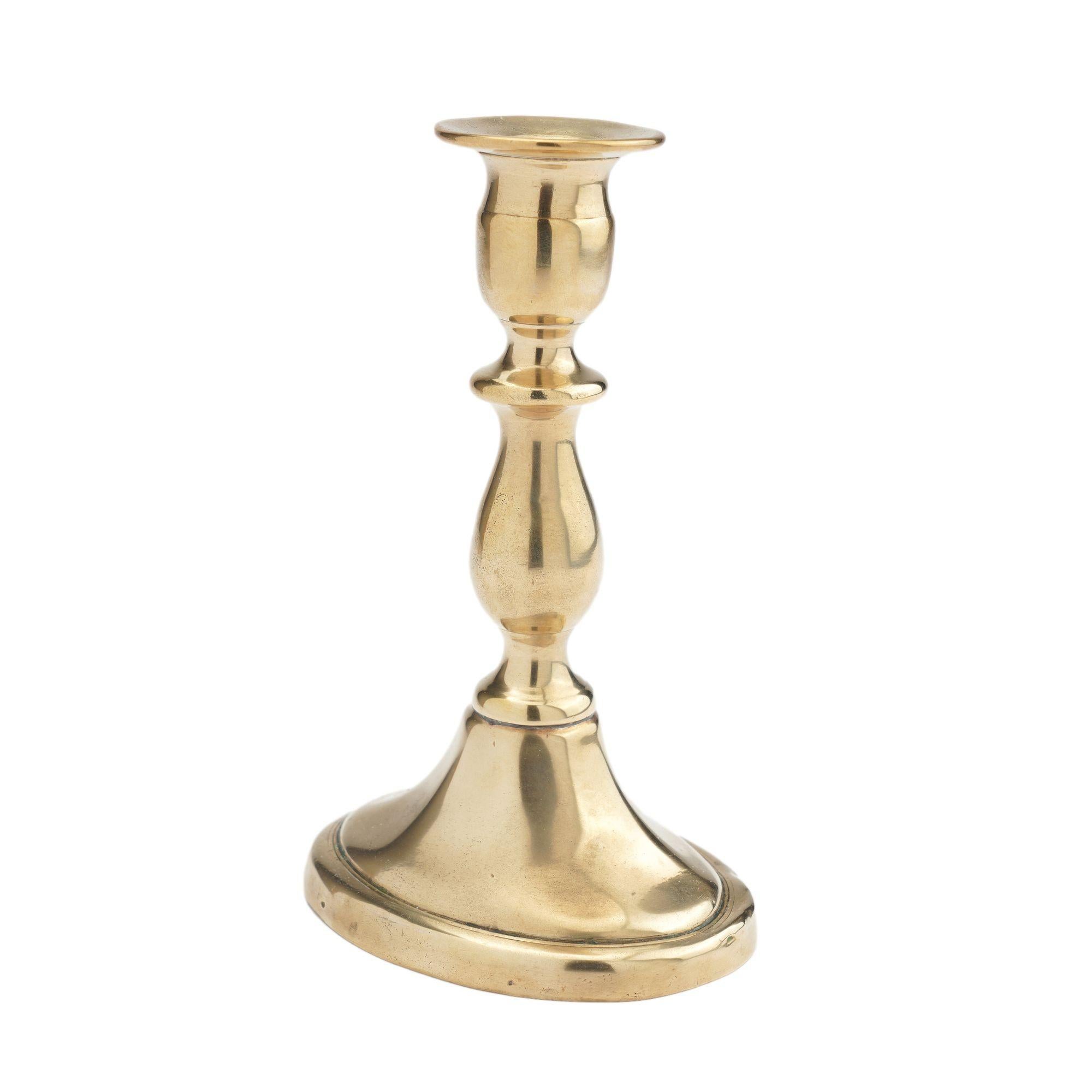 Rare oval base, core cast brass candlestick with baluster shaft and urn form candle cup with bobesh. The candle shaft retains its original push up candle ejector and the underside of the base bears the initial 