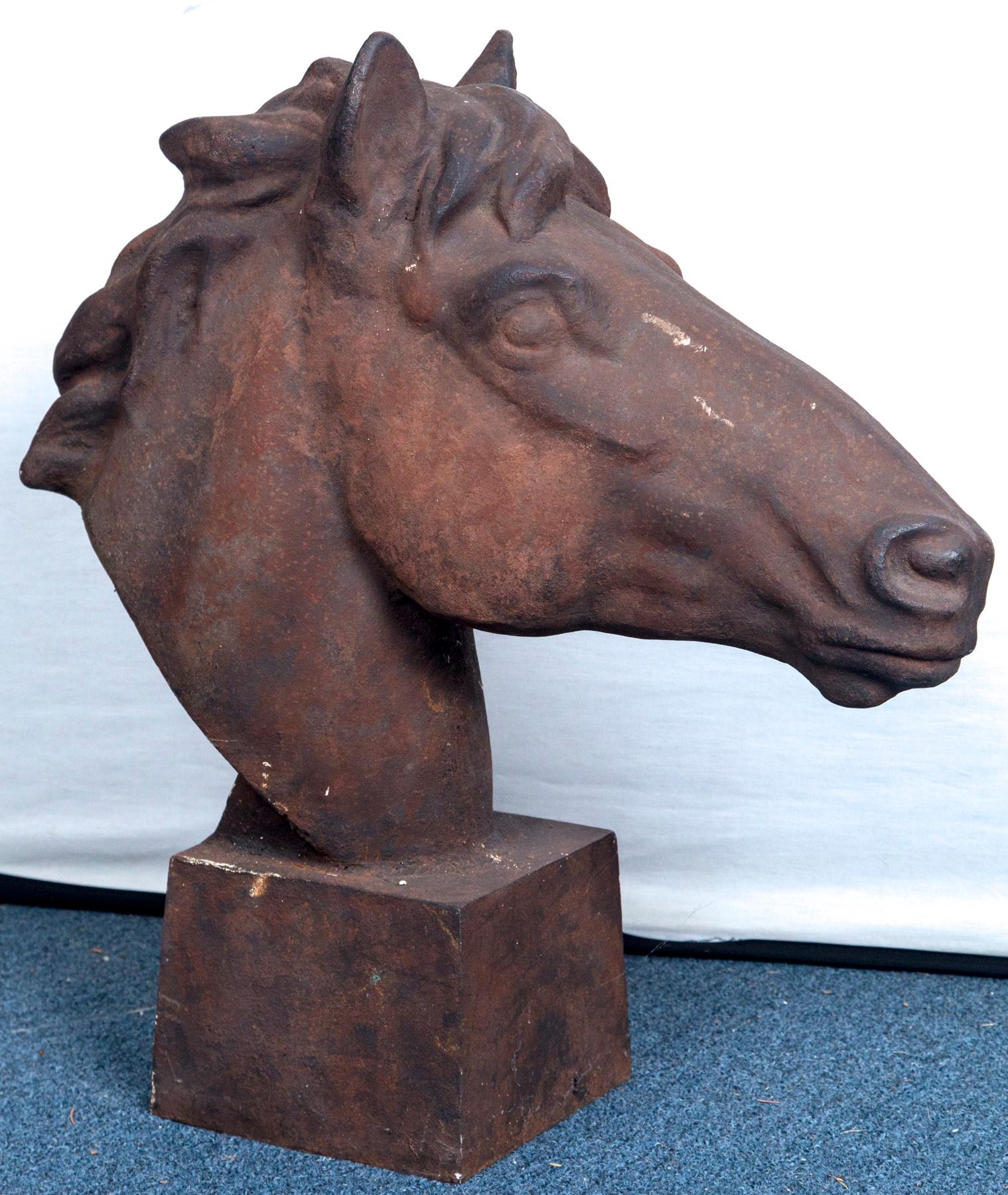 A large rust patina cast iron horse head figure on a square base.