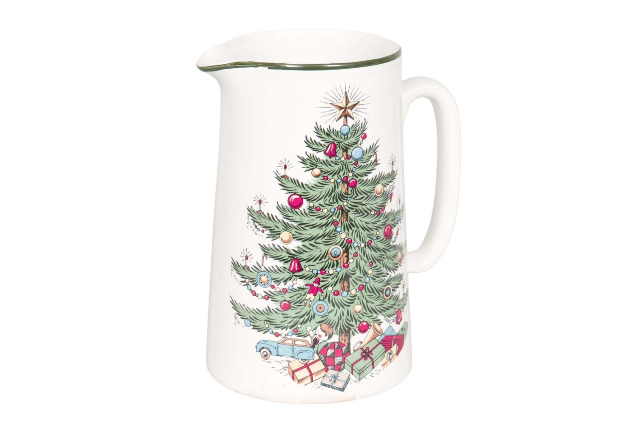 An English ceramic pitcher decorated with the ‘Original Christmas Tree’ pattern made by Cuthbertson. In front is featured the beloved Christmas Tree topped with a radiant star and adorned with colorful ornaments, with wrapped gifts, a toy car, doll