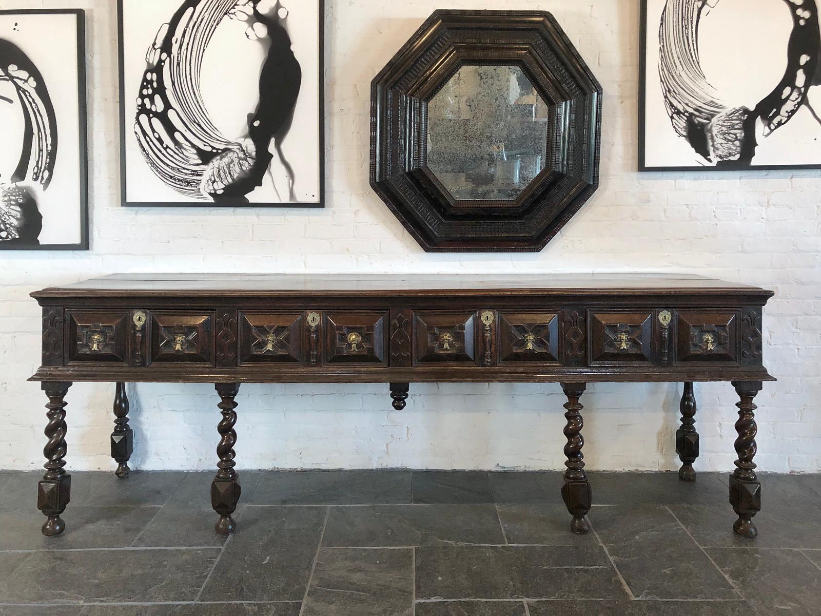 Credenza in Oak Charles II, eccezionalmente lunga e stretta, risalente al 1670 circa. Il piano rettangolare a due tavole con bordo modanato, sovrasta un fregio contenente quattro cassetti con audaci fronti modanati architettonicamente, ornati da