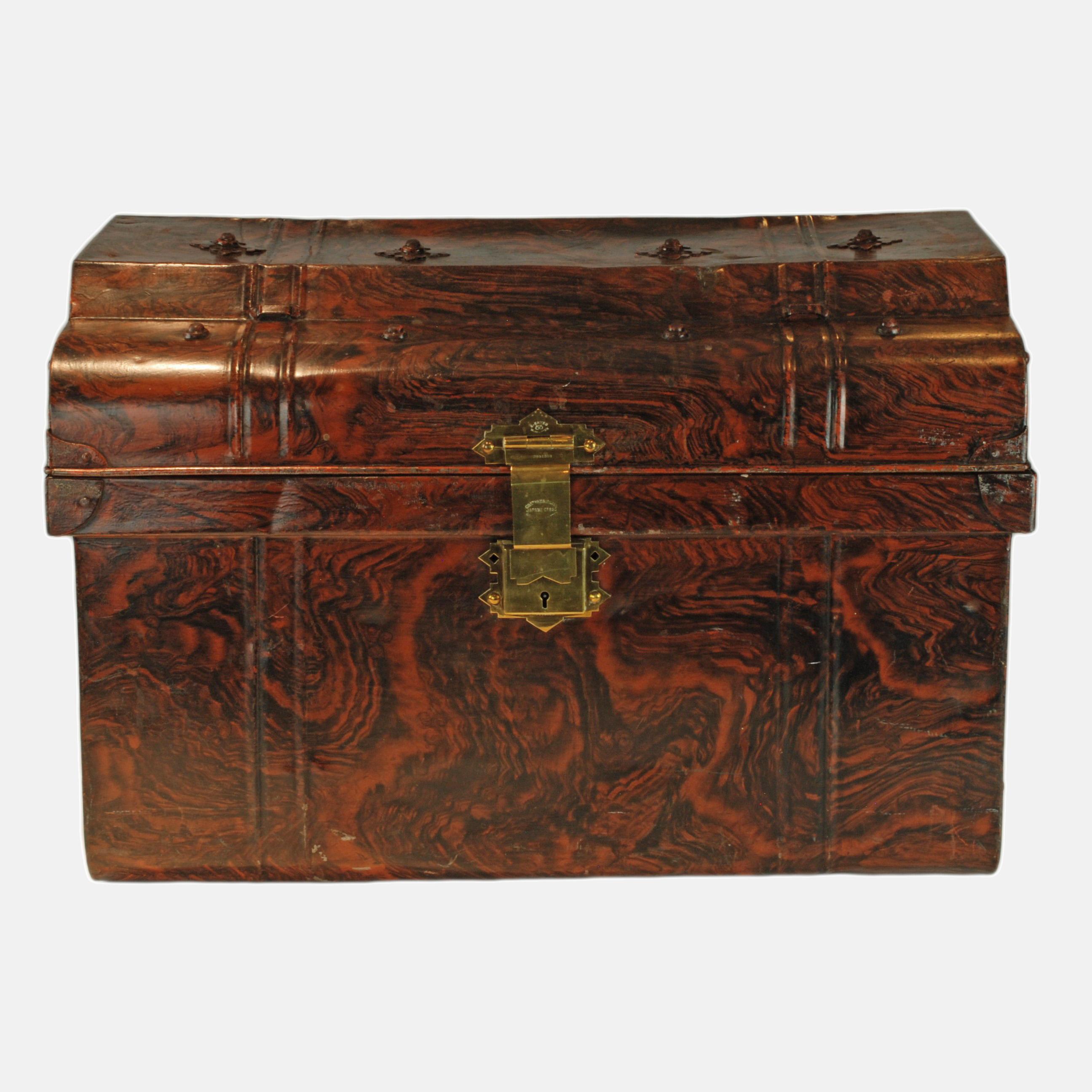 This Edwardian cold rolled annealed steel travel steamer trunk was made in Wolverhampton England by Chatham & Wilkes.  The trunk has been decorated in a faux bois pattern with beautiful graining.  The domed lid has a raised rectangular section at