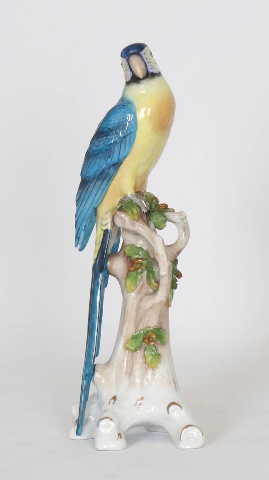 Porcelain parrot by Chelsea house marked with the gold anchor period (1756-1769). Manufactured in England, the parrot is perched on a branch and features tones of yellow and blue. This piece is in excellent vintage condition having wear consistent