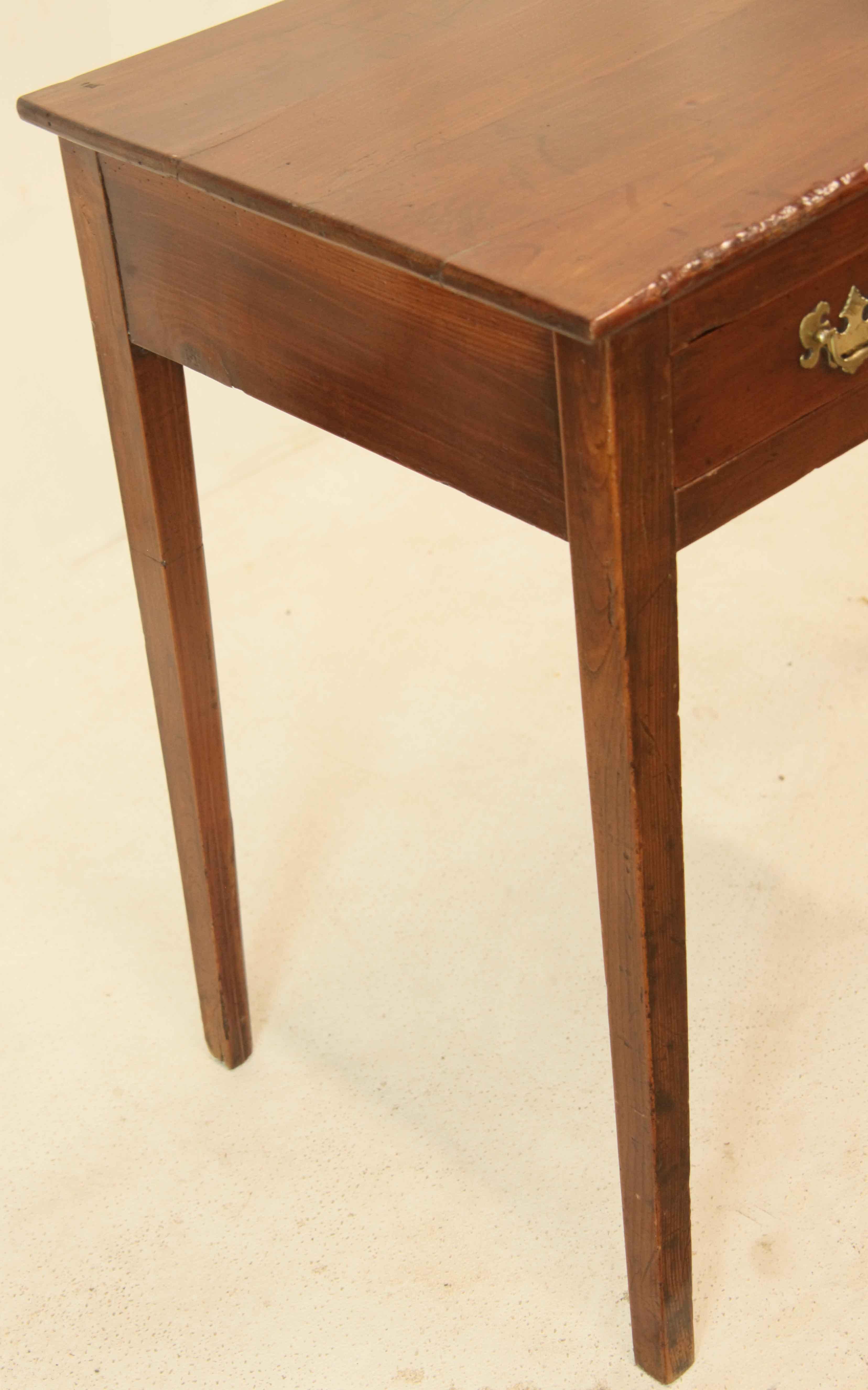 English cherry one drawer side table, the top has beautiful cherry grain and color,  single long drawer with ''bat wing'' brass pulls and oval escutcheon.  The legs have good proportion, are nicely tapered, and have a very slight chamfer on the