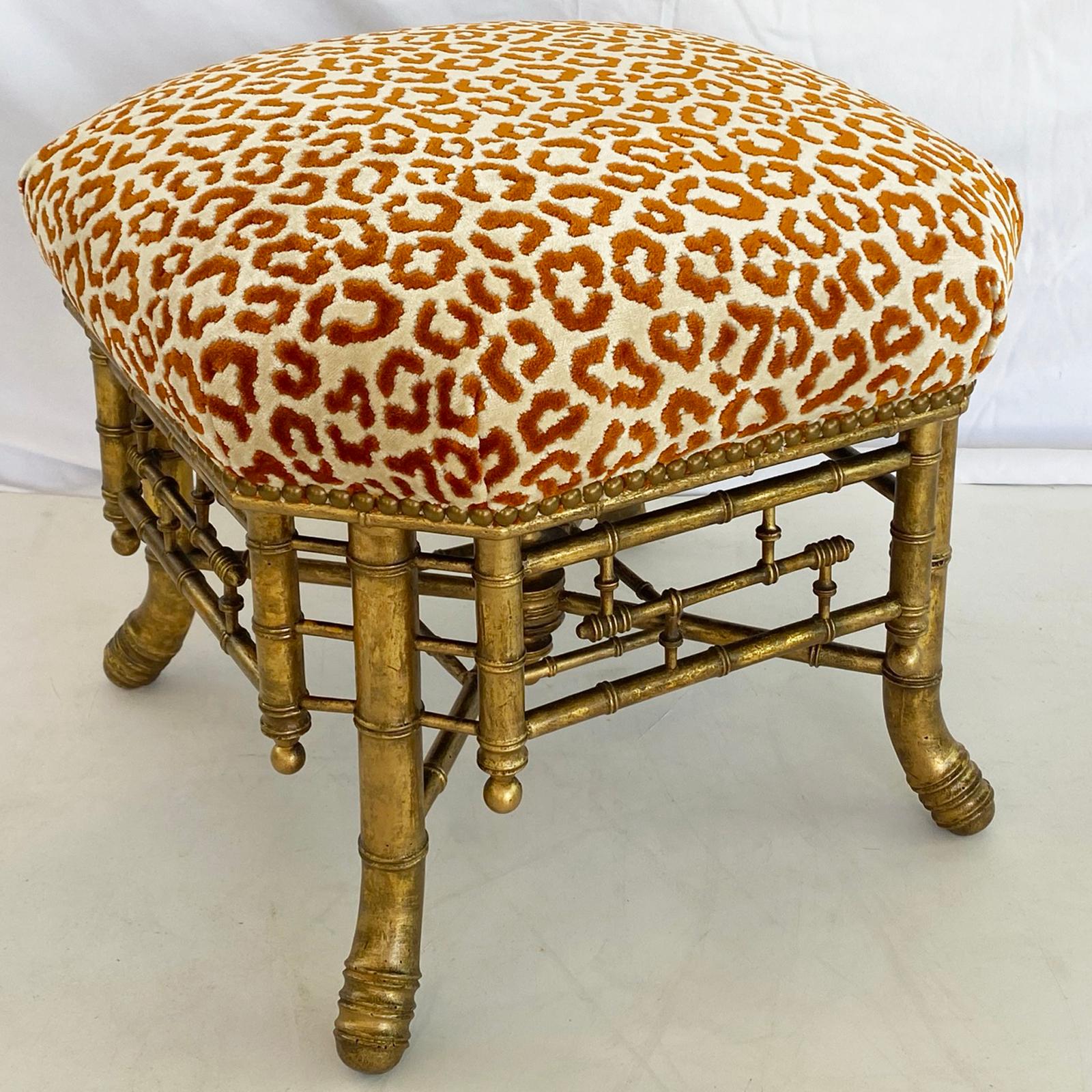 English Chinese Chippendale style gilded faux bamboo stool from the mid-19th century, its square crown seat with canted corners upholstered with a leopard print cut velvet in orange and cream colorway with nailheads, raised on four splaying legs,