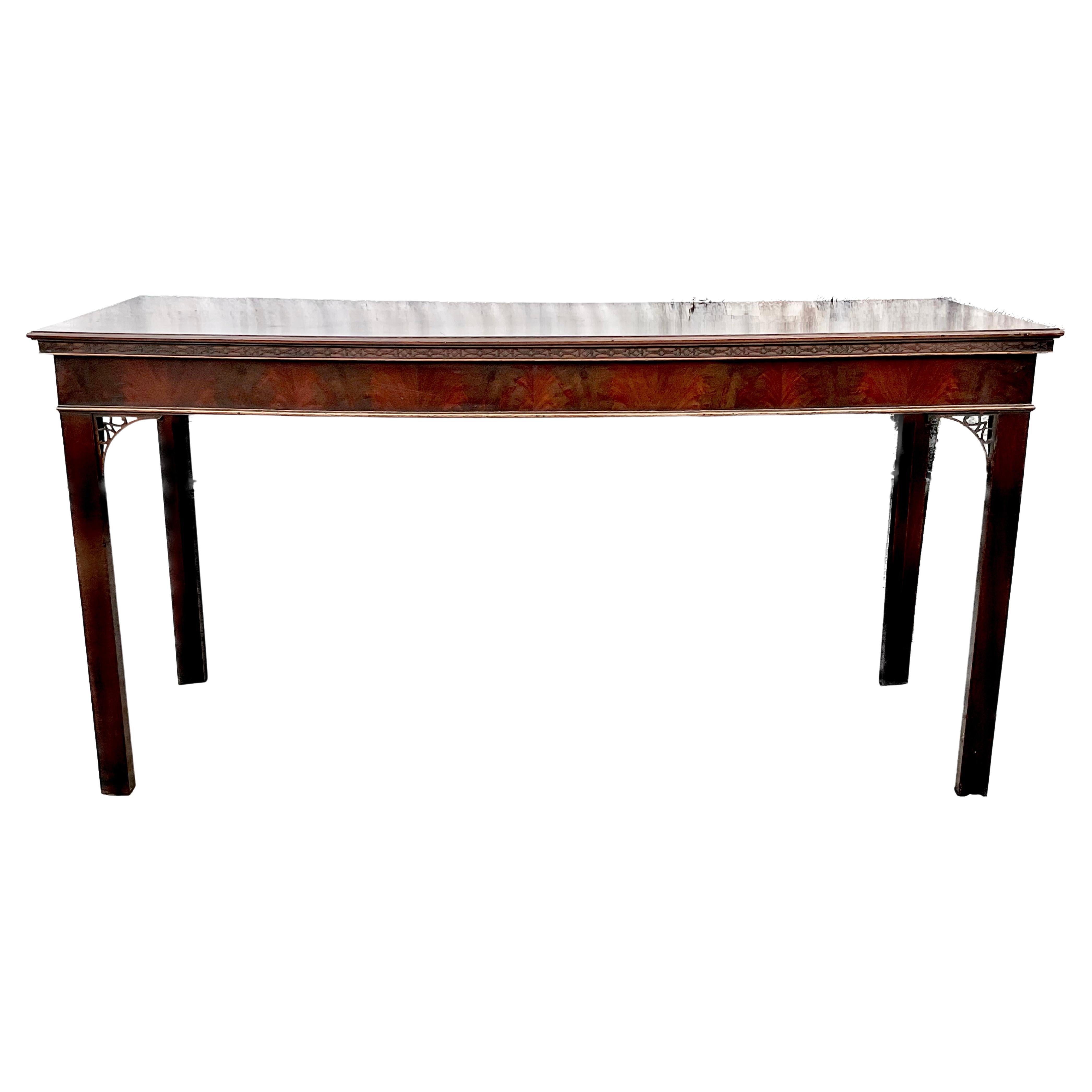 George III Chinese Chippendale Mahogany Serving Table. English. Table has a rectangular top with carved molded edge in the Chinese Chippendale manner over a wide frieze apron with a cockbead molding. It is raised on square legs with chamfered