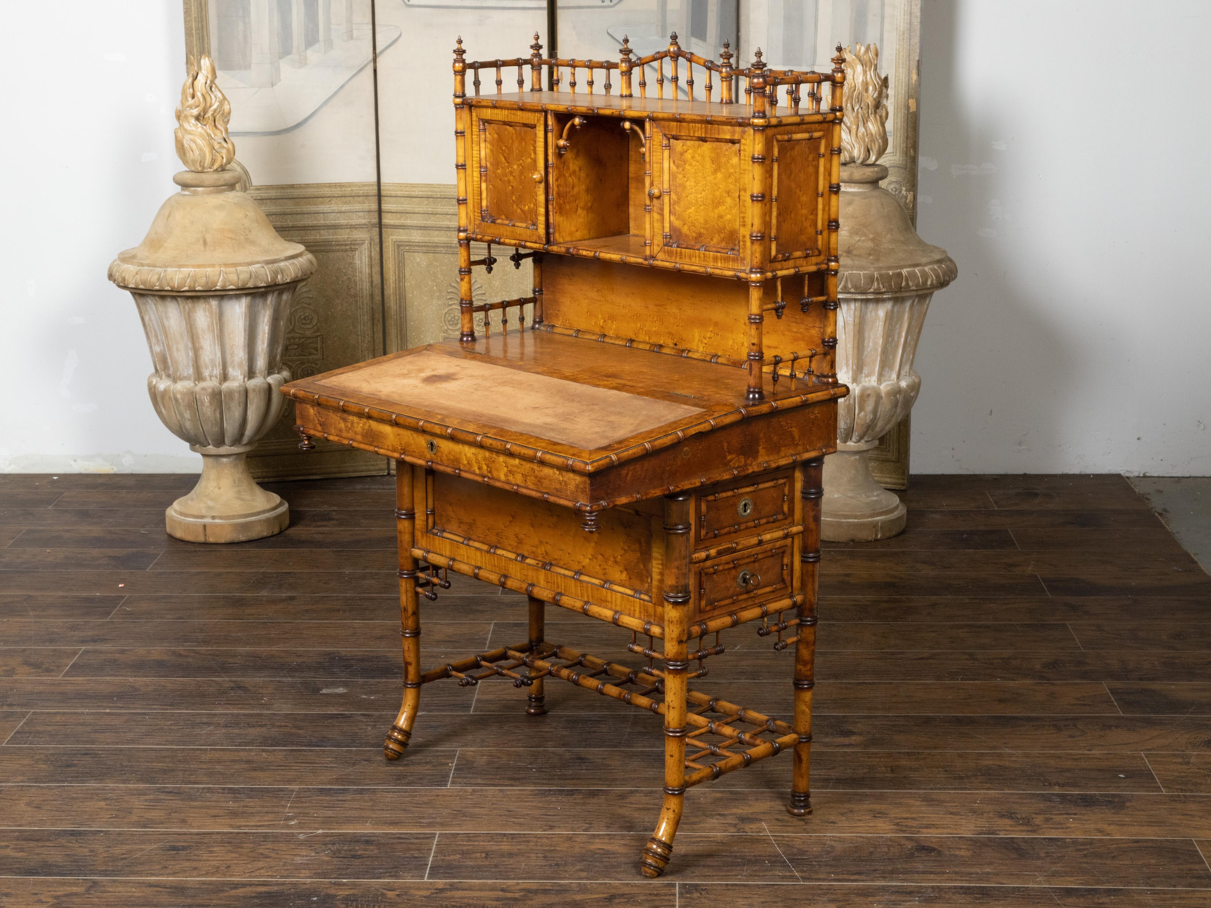 An English Chinese Chippendale style tall bamboo secretary from the 19th century, with slanted lift-top writing table, doors and drawers. Created in England during the 19th century, this bamboo secretary charms us with its slender proportions and