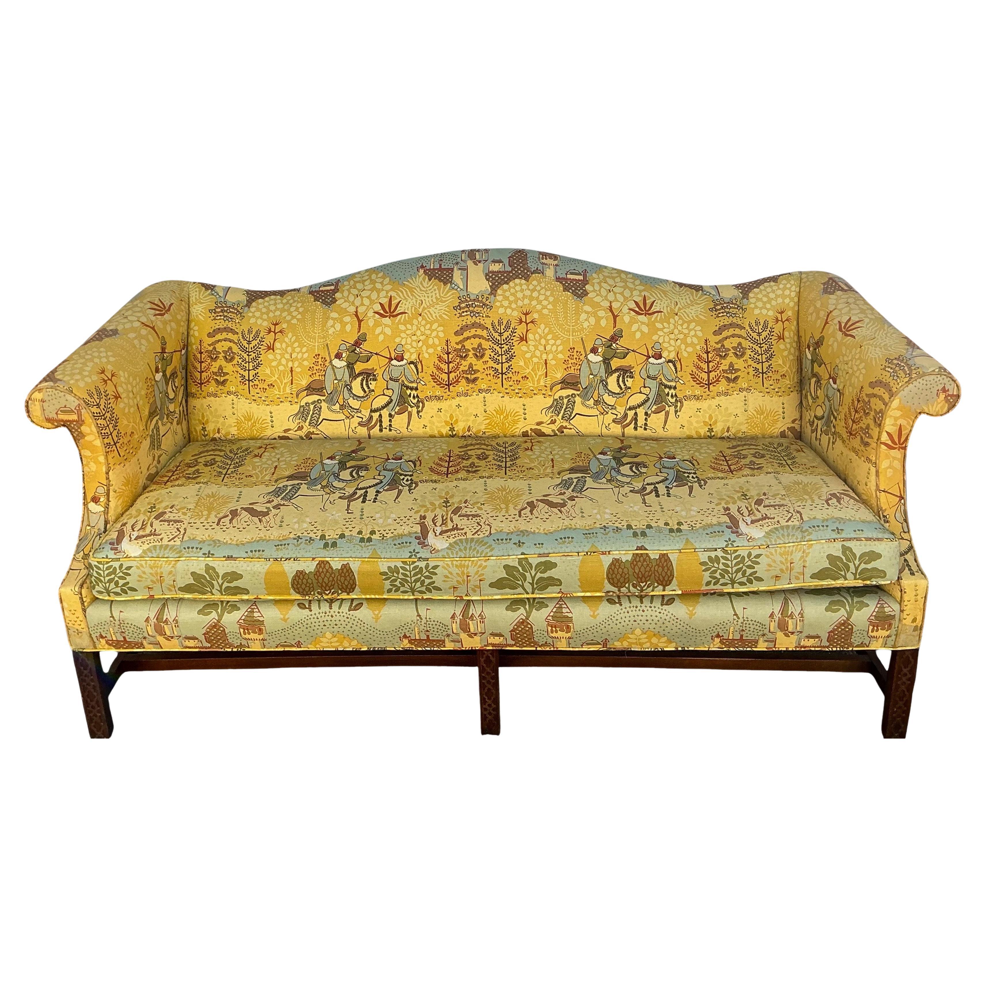 This is an English Chinese Chippendale style camelback sofa upholstered in an old world linen with a carved mahogany frame manufactured by Hickory Chair Co the linen upholstery is in very good condition. The only spot is on the decking. It is