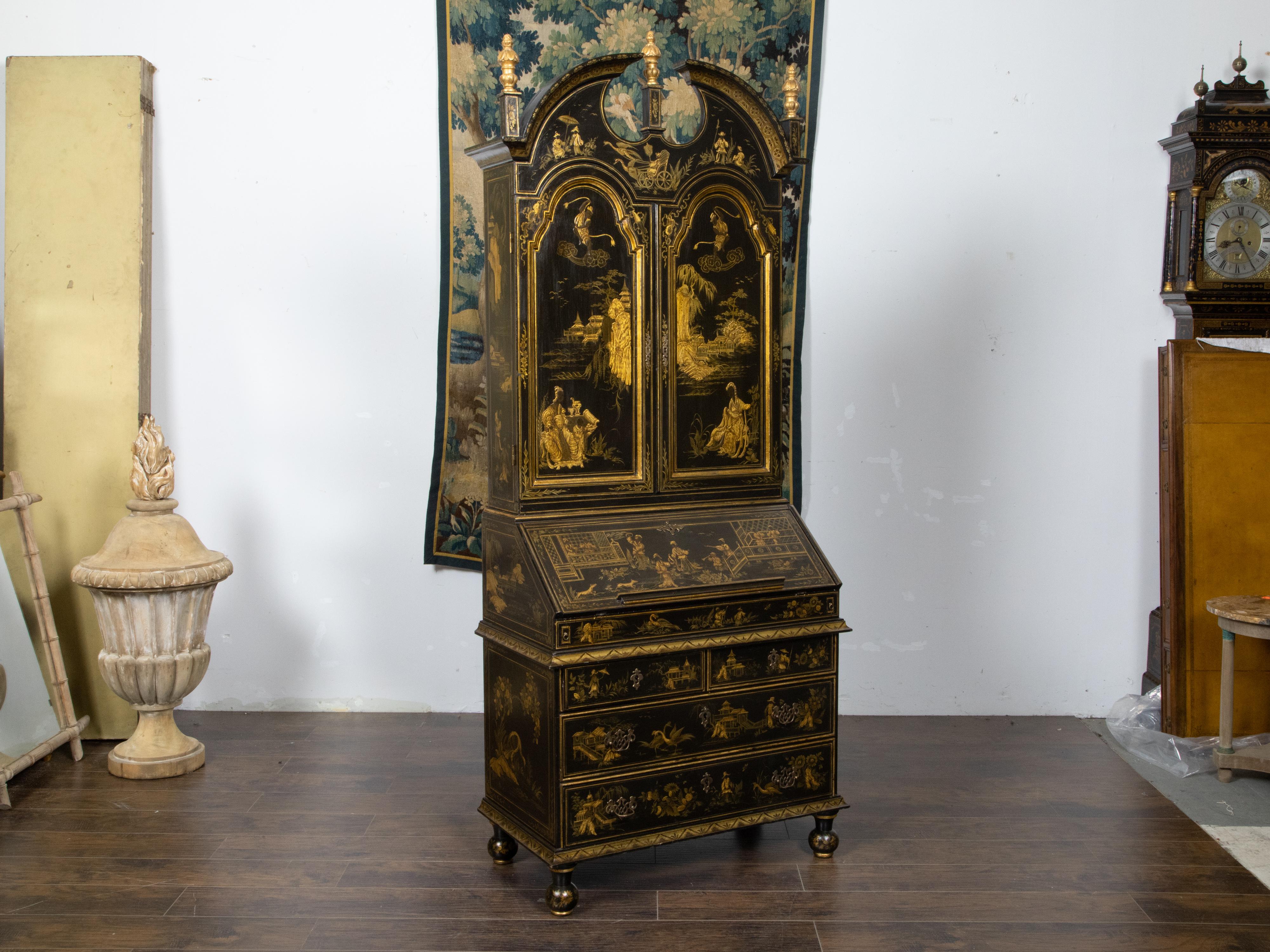 An English tall Japanned secretary from the early 20th century with black and gold chinoiserie décor, slant front desk, broken arch pediment and multiple drawers. Created in England during the first quarter of the 20th century, this tall secretary