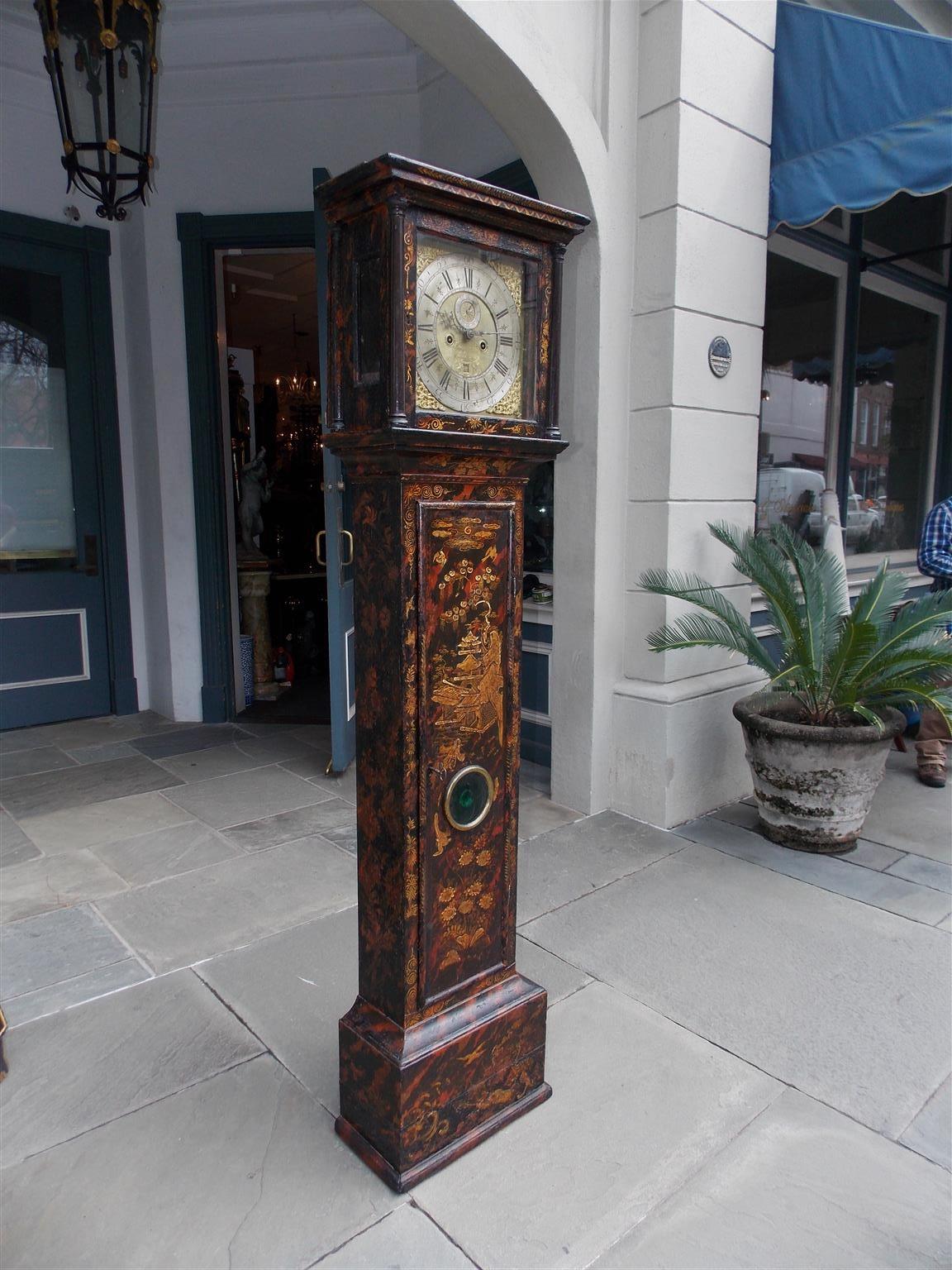 English chinoiserie black lacquered and gilt stenciled tall case clock with a steel numeral engraved face surrounded by flanking cherubs and crown ormolu mounts, removable hood with quarter columns, glass hinged door, gilt stenciled pagoda, bird,