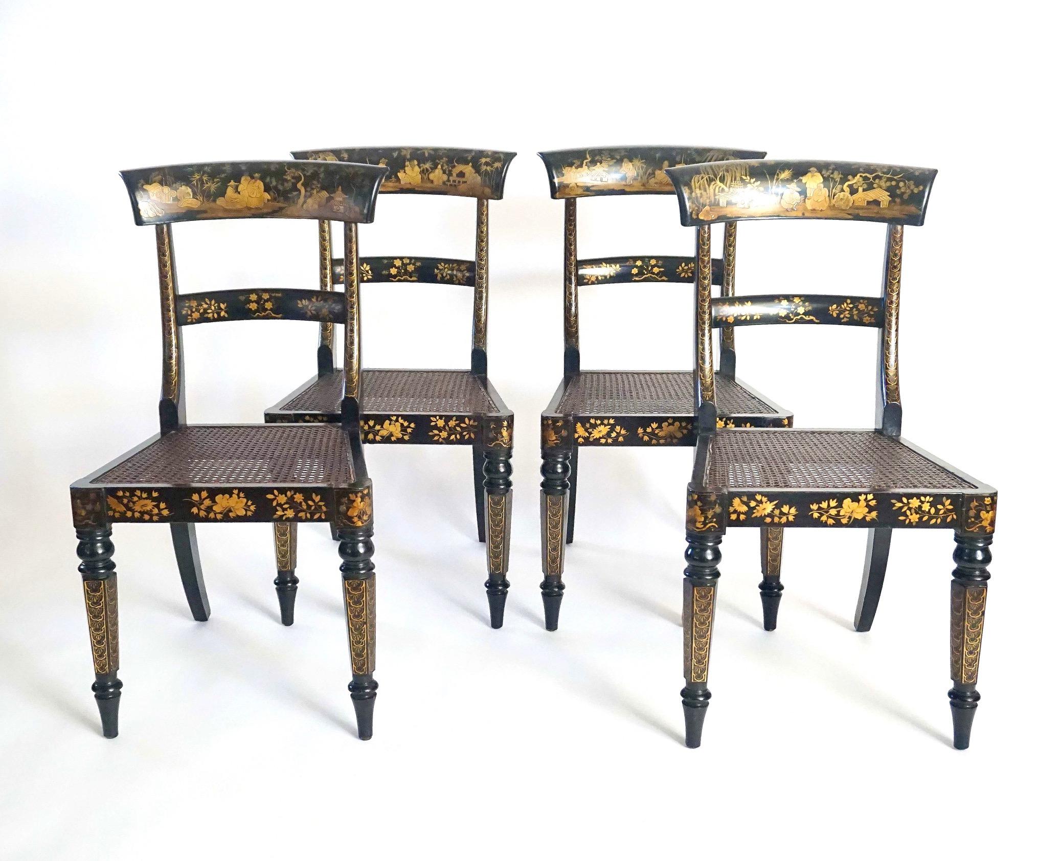An exceptional and important set of four circa 1835 English William IV, or early Victorian period, side or breakfast chairs of Regency parcel-klismos form having black Japanned frames with allover gilt relief chinoiserie landscape and foliate