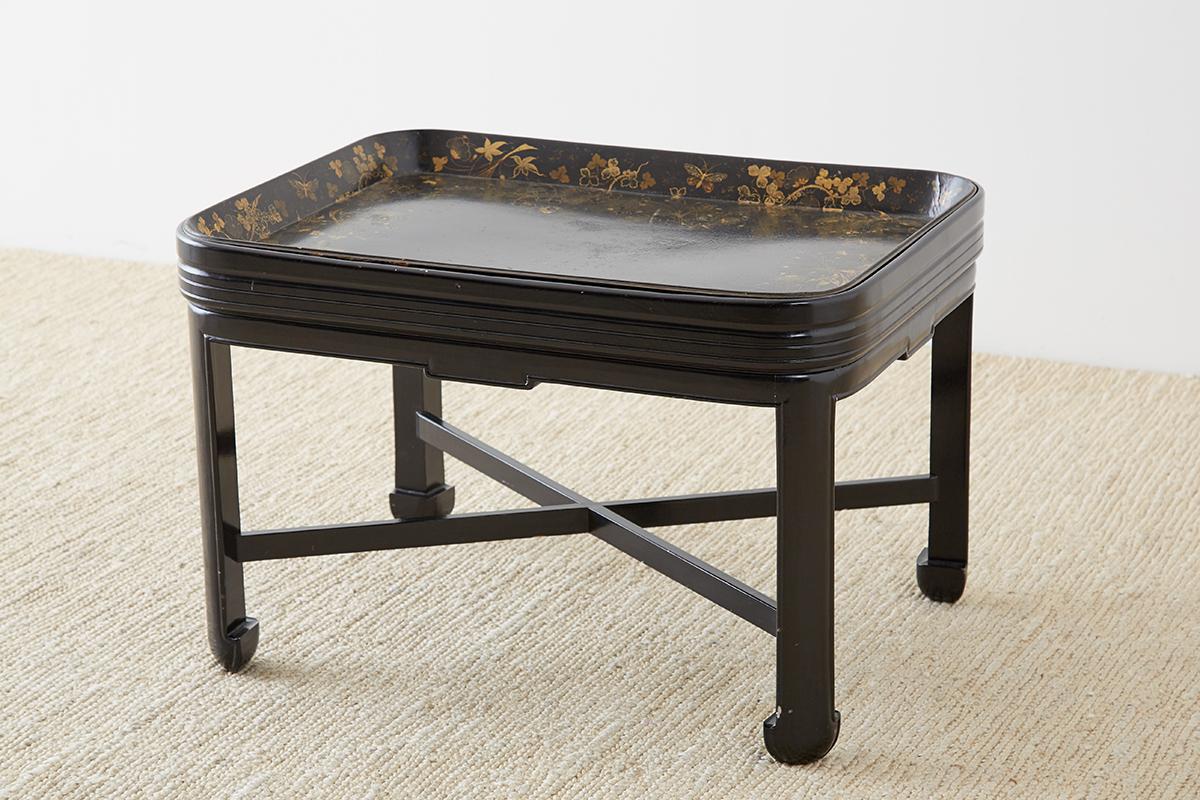 Early 19th century English chinoiserie tray table constructed from Japanned papier mache. Produced by Henry Clay's Clay of King St. London with makers mark on bottom. Set in a later ebonized wooden stand featuring Asian chow feet legs. The tray fits