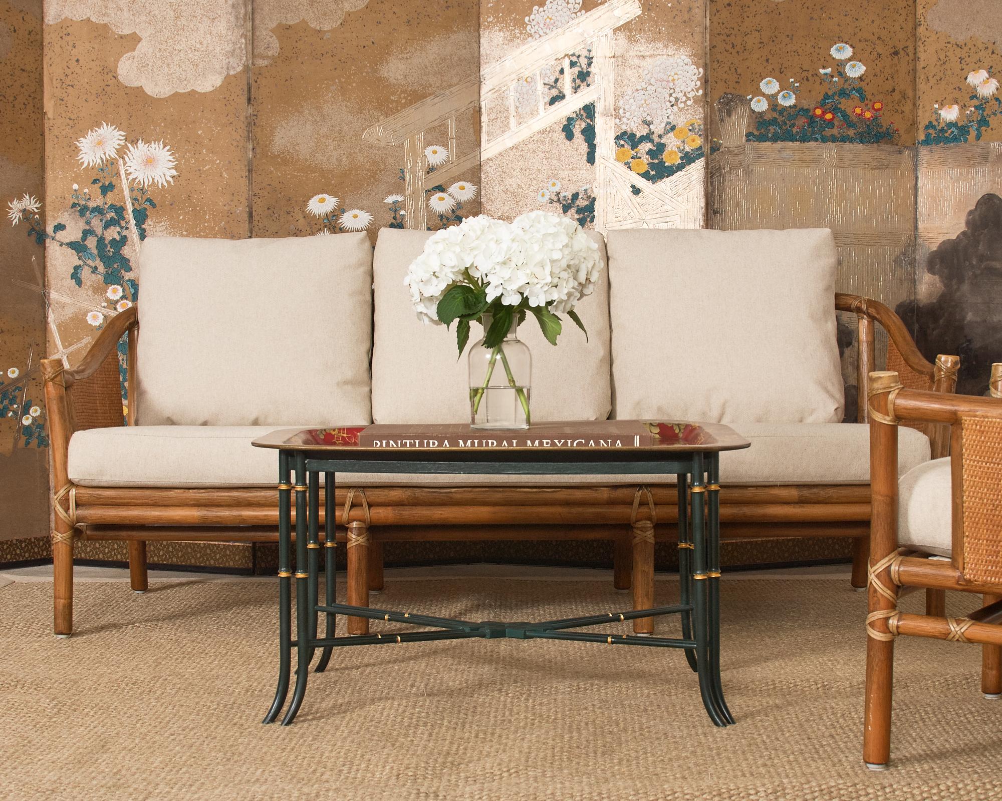 Charming English chinoiserie style faux bamboo cocktail table featuring a paper-maché lacquered tray top decorated with intricate Asian motifs. The tray has parcel gilt pagodas and landscapes over a dramatic red ground. The lacquer has a desirable