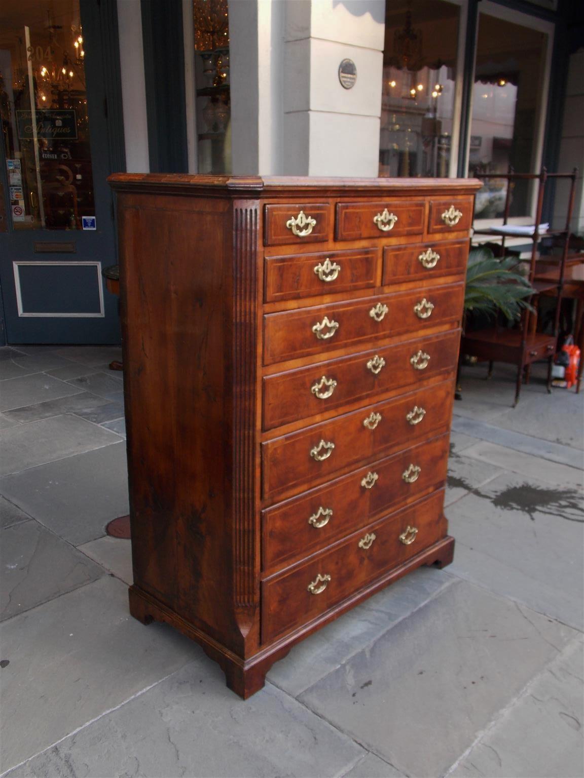 English Early Chippendale burl walnut graduated tall chest with a carved molded edge cornice, flanking fluted side columns, hearing bone inlays, original brasses, and terminating on the original bracket feet, Early 18th century.
