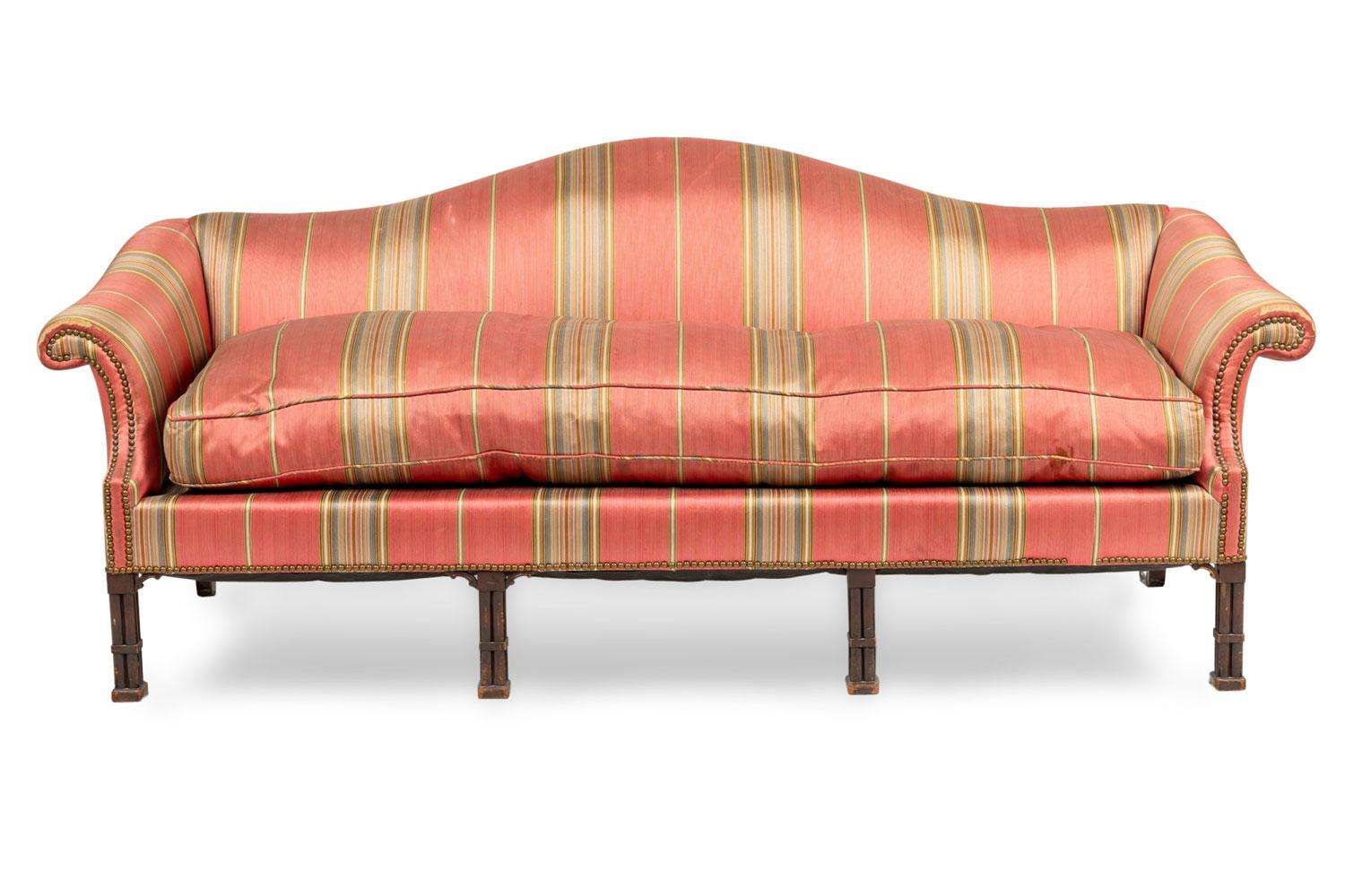 Canapé / sofa à dos de chameau de style Chippendale anglais (1ère moitié du 20ème siècle) avec des accoudoirs roulés et un grand coussin d'assise avec une tapisserie rayée rouge et blanche reposant sur des pieds avec une colonne à 4 grappes en faux