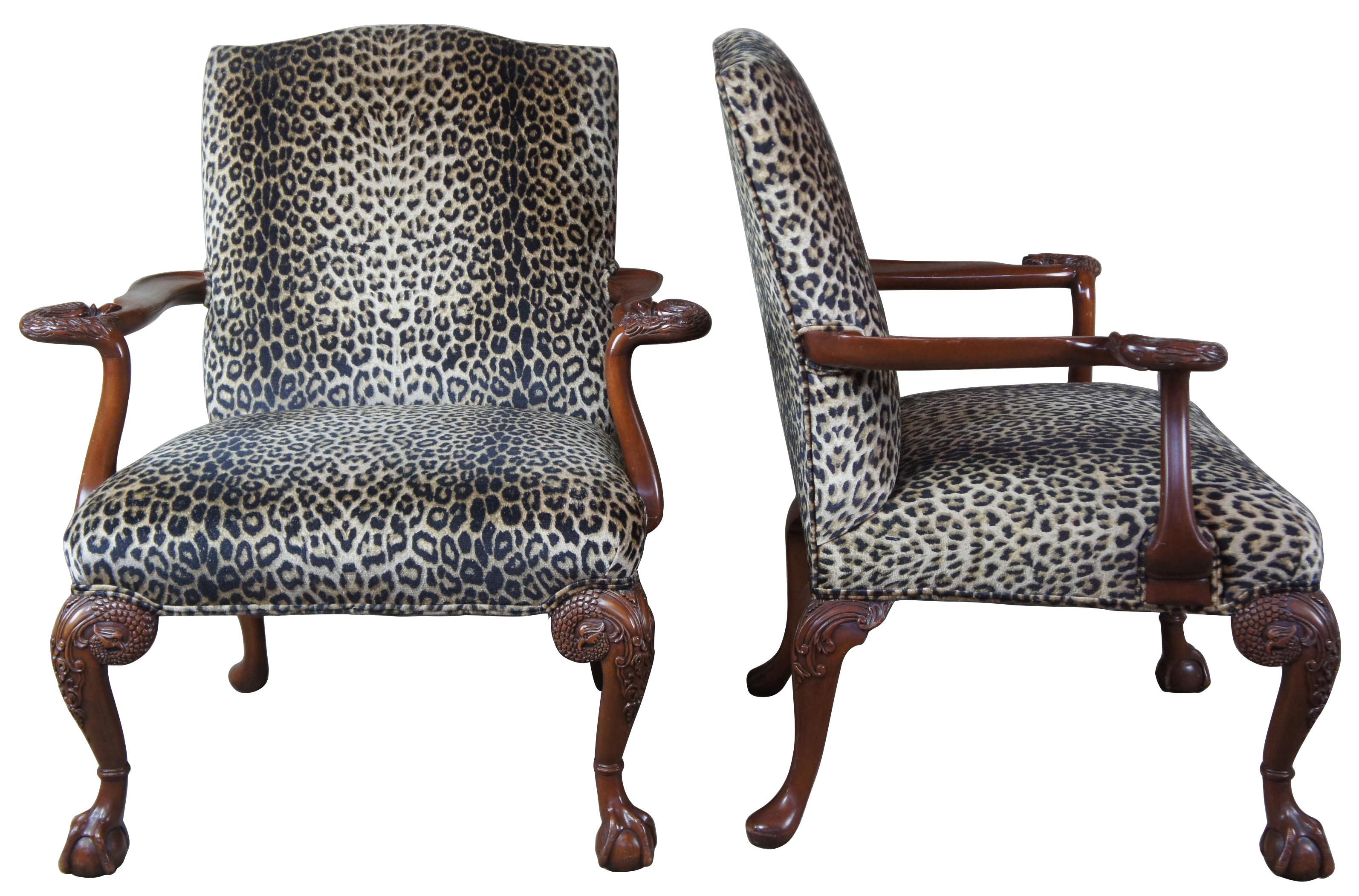 Two mid-20th century oversized Chippendale style mahogany Gainsborough armchairs. Features flared swan carved arms leading to a leopard covered seat over serpent carved legs over ball and claw foot.