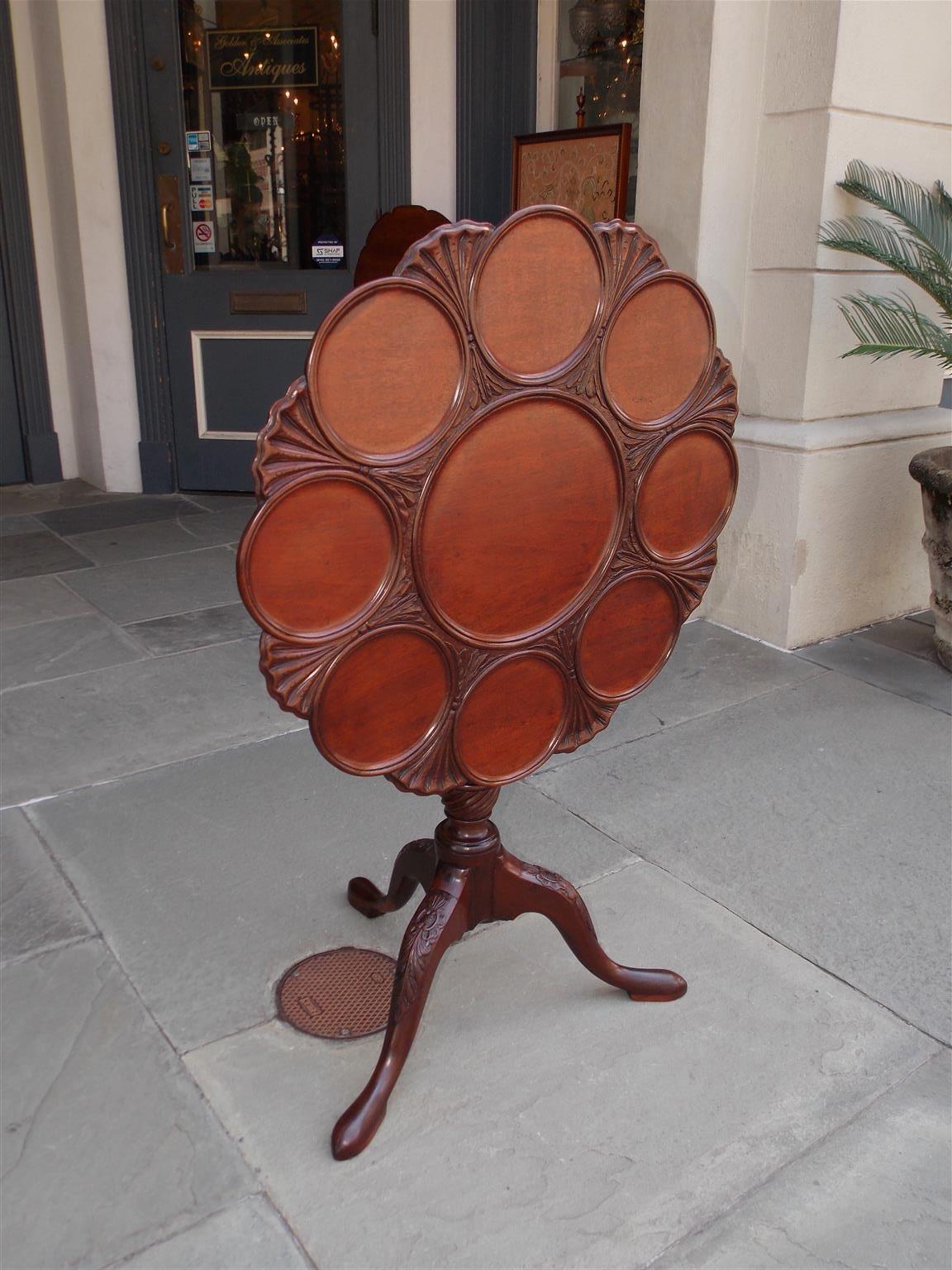 English Chippendale mahogany tilt top dessert table with circular inserts flanked by shell and acanthus carvings, turned ringed spiral center pedestal, original locking mechanism, and terminating on the original acanthus carved knees with snake