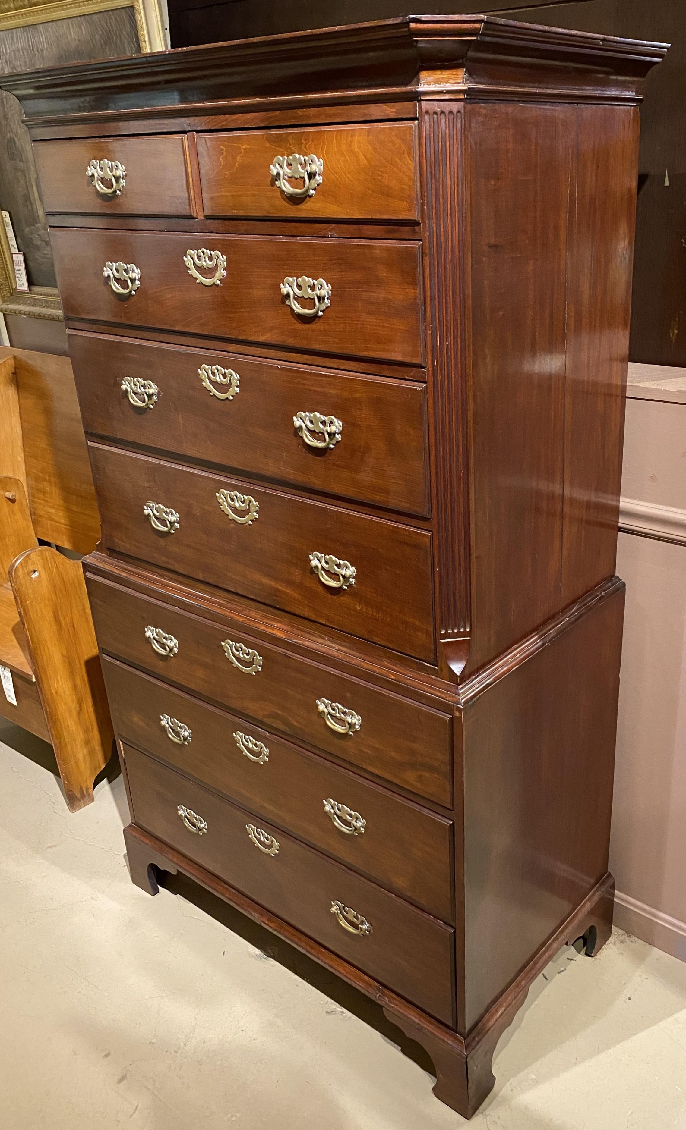 A fine English Chippendale mahogany two part chest on chest, its upper case with a molded cornice surmounting a two over three drawer configuration, flanked by canted reeded corners, over a lower case with three long drawers, all with what appear to