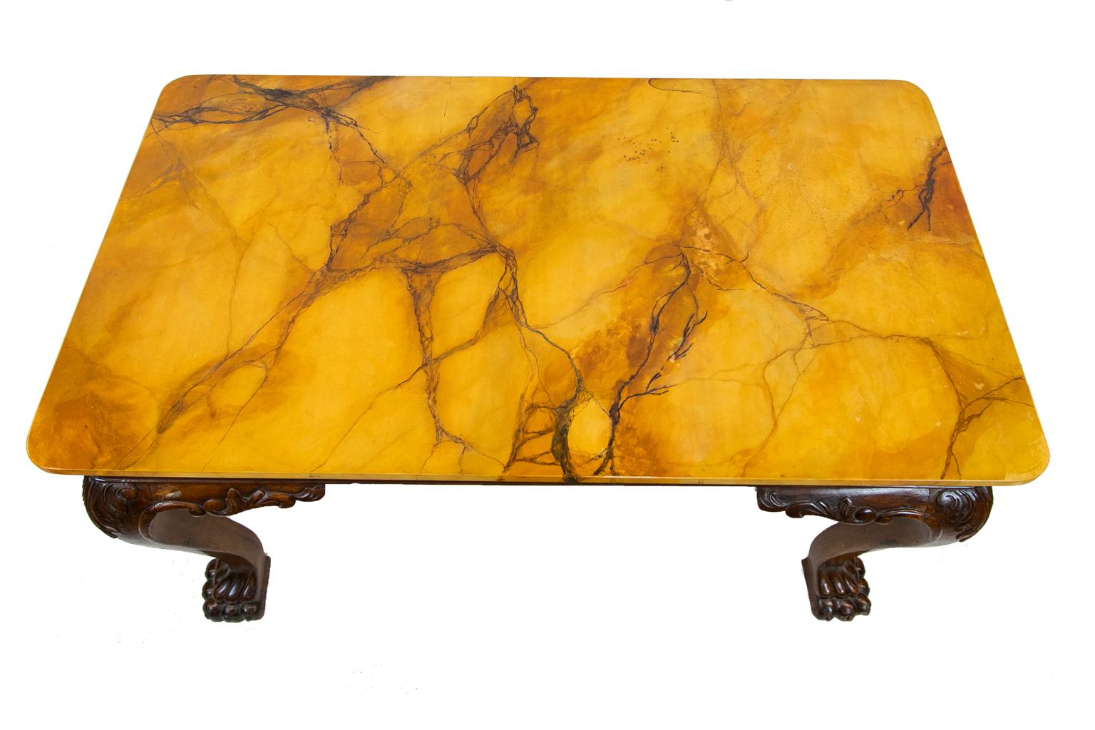 English Chippendale simulated marble-top center table is faux painted to simulate Sienna marble. The apron is bookmatched banded in mahogany with very large cabriole legs. There are acanthus leaf carvings in high relief on the legs which terminate