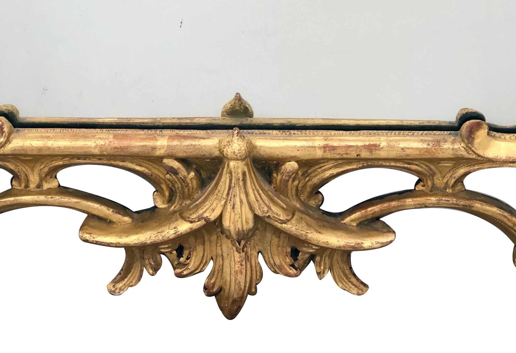 Well-carved giltwood wall mirror with a pagoda-form pediment above an open-work carved foliate frame.