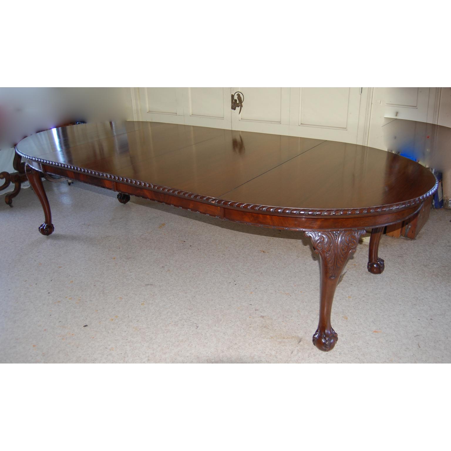 English Chippendale style mahogany banquet table with two leaves, acanthus leaf carved cabriole legs, ball and claw feet, the top with gadrooned carved edge. This versatile table easily cranks out and in to accommodate none, one or two leaves. The
