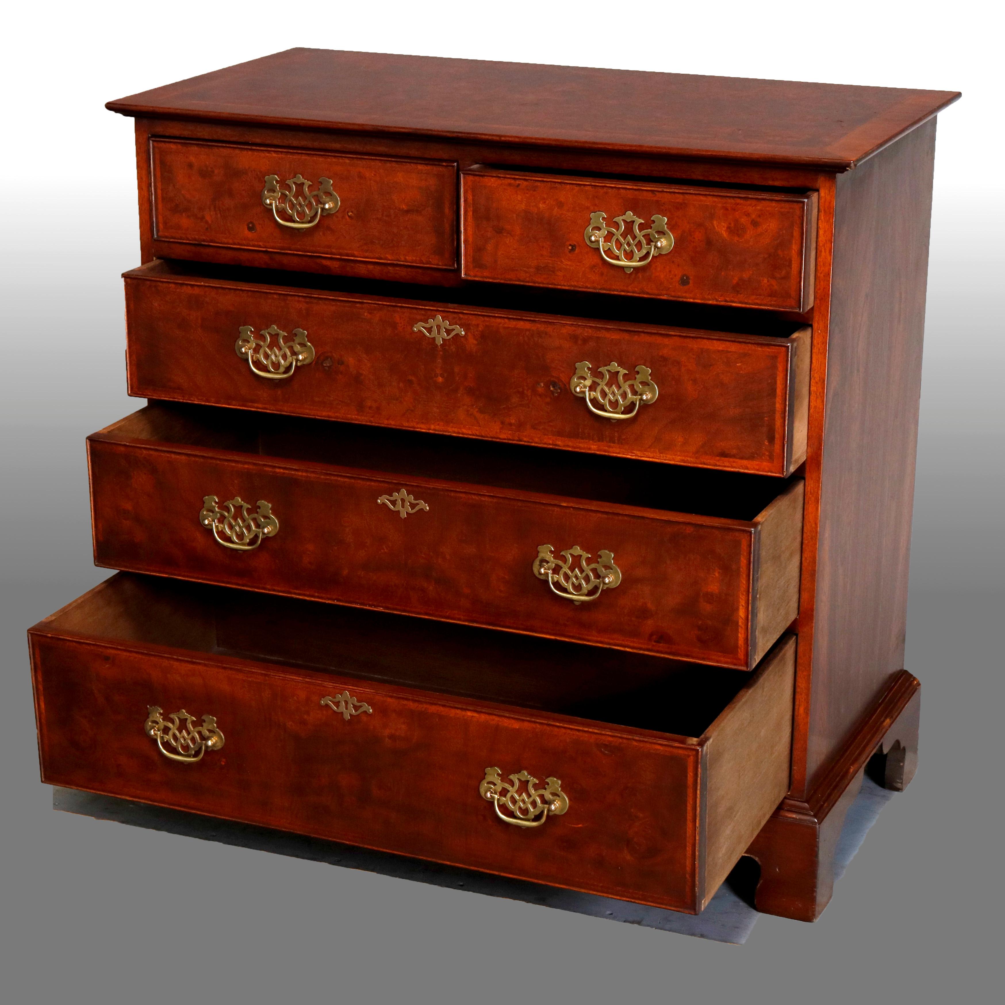 An English Chippendale style chest of drawers offers flame mahogany construction with crossbanded top surmounting case with two smaller drawers over three long drawers and raised on bracket feet, pierced brass pulls throughout, 20th century
having