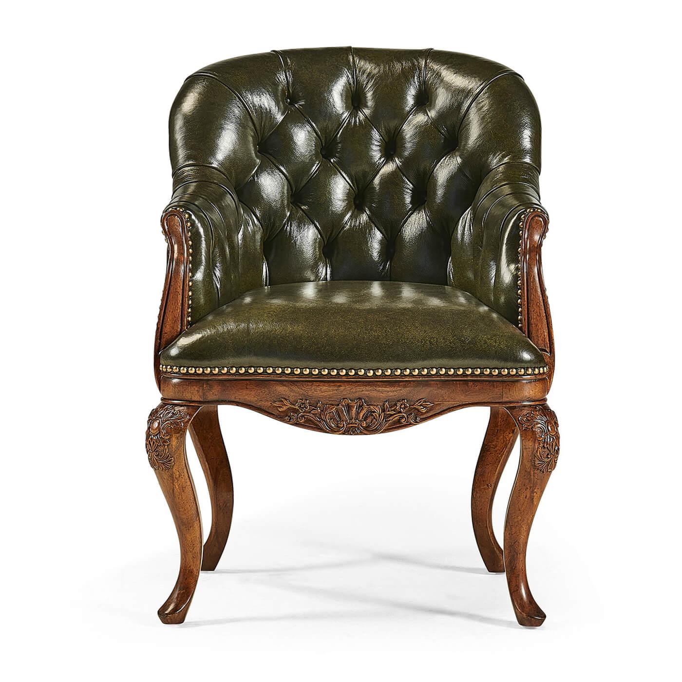 An English Chippendale style Library armchair with button tufted green leather, with scrolling arms set on carved cabriole legs with carved floral decoration and brass nailhead details.

Dimensions: 26 3/4