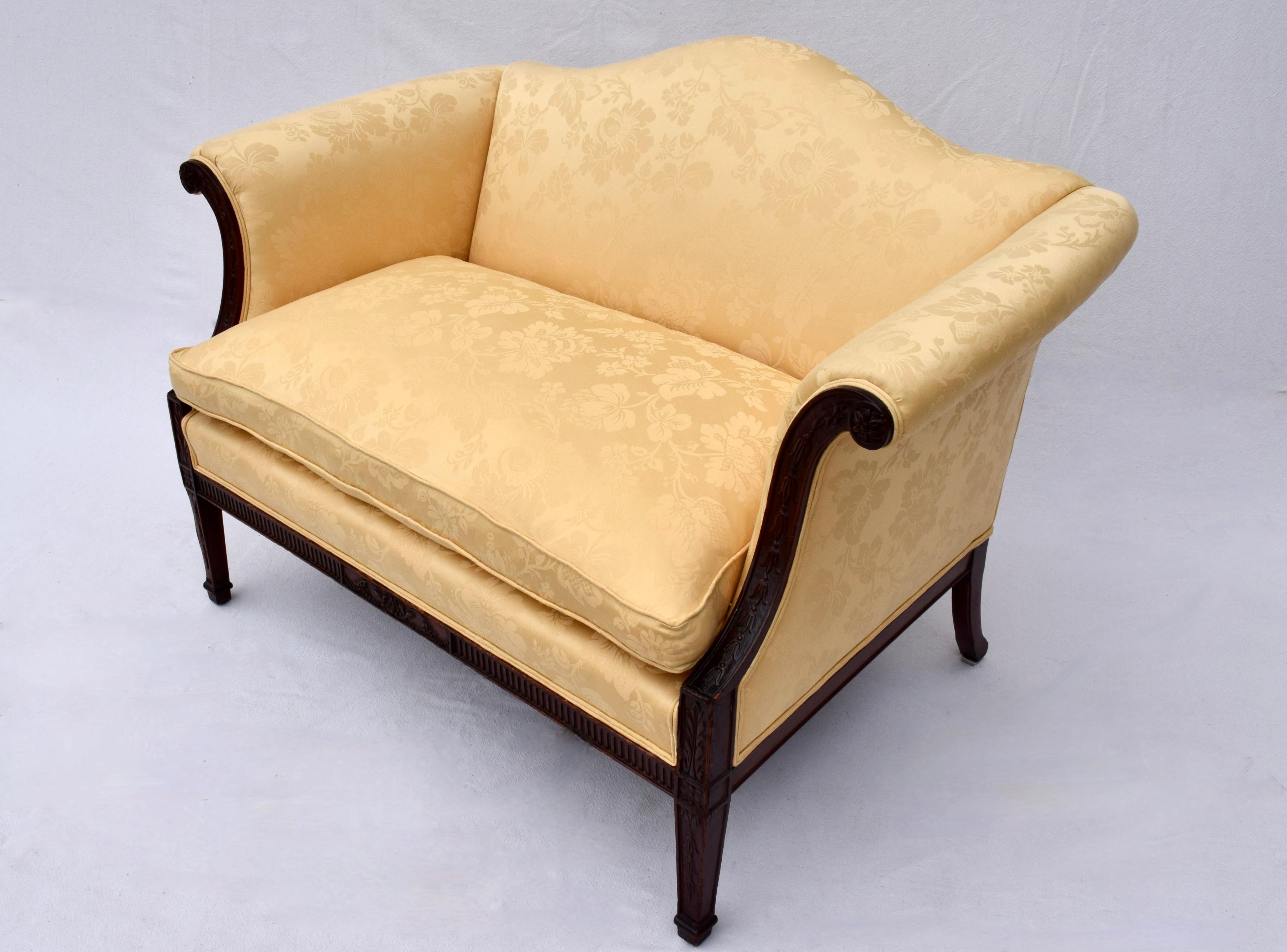 Un diminuto sofá de caoba estilo Chippendale de principios del siglo XX, con cojín de felpa relleno de pluma de ganso y armazón tallado a mano; recién tapizado en llamativo damasco amarillo canario. 
Asiento: 22